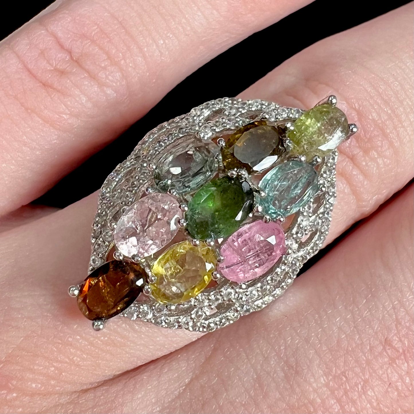 A silver gemstone cluster ring set with a rainbow of multicolored tourmaline stones.