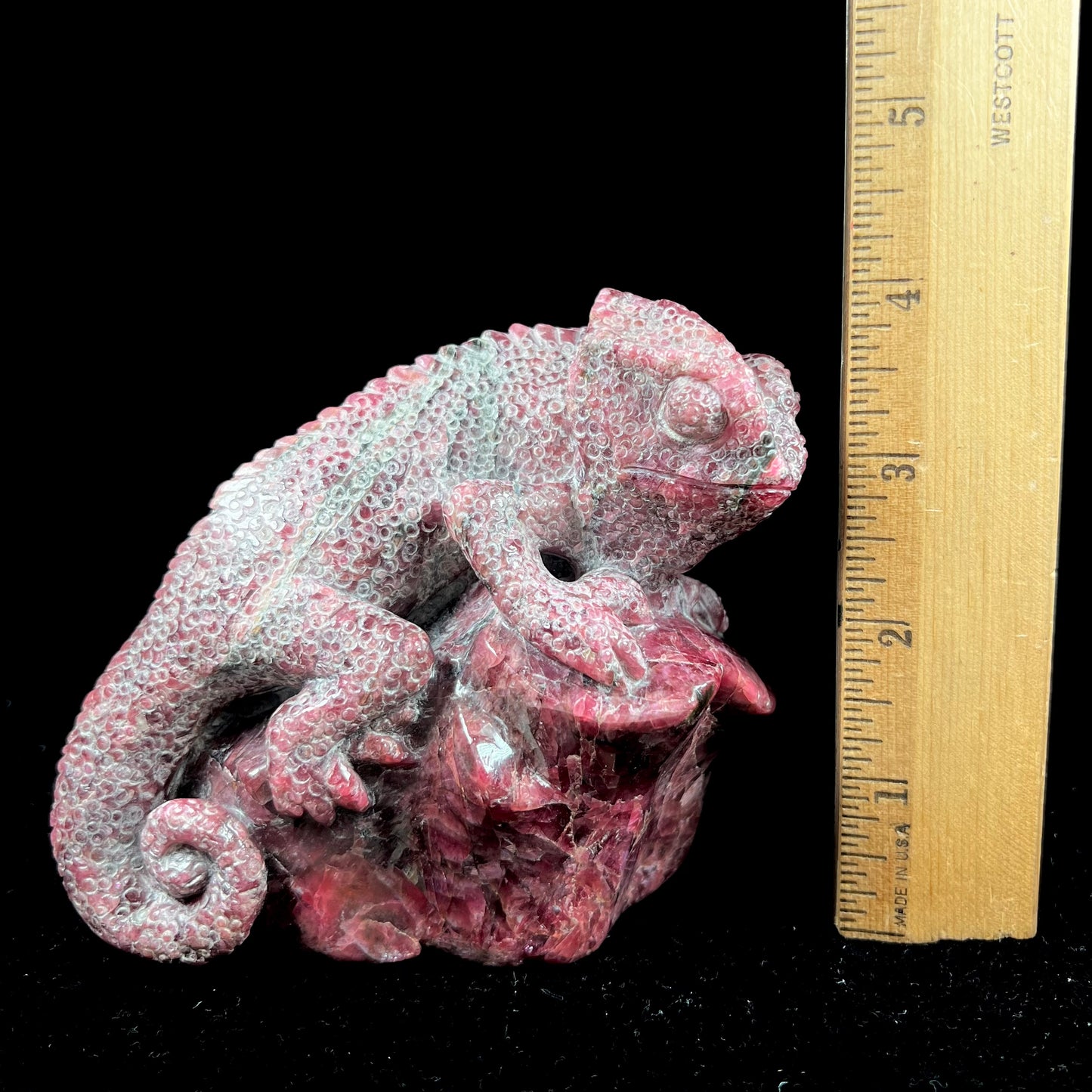 A stone chameleon lizard carved from natural rhodonite by artist, Ronald Stevens.