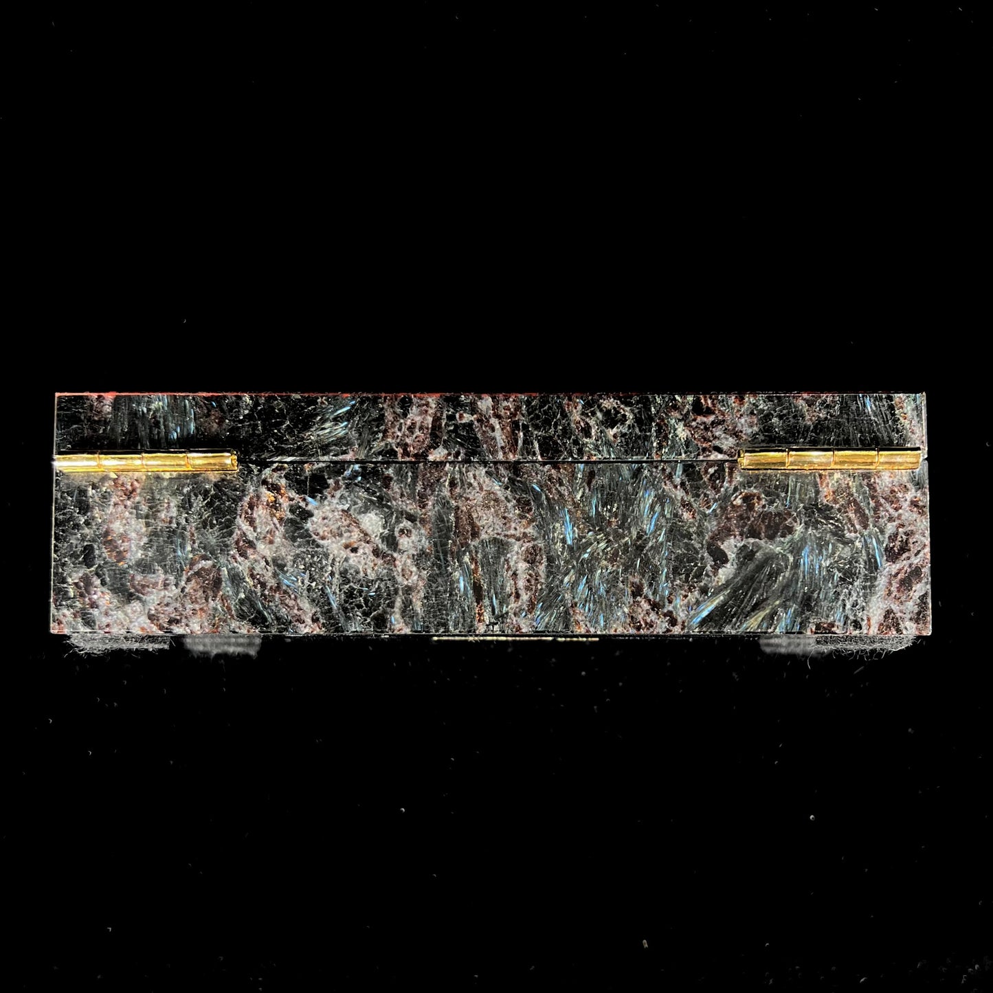 A custom stone box handmade by Gems Art Studio from polished red dinosaur bone and blue pietersite.
