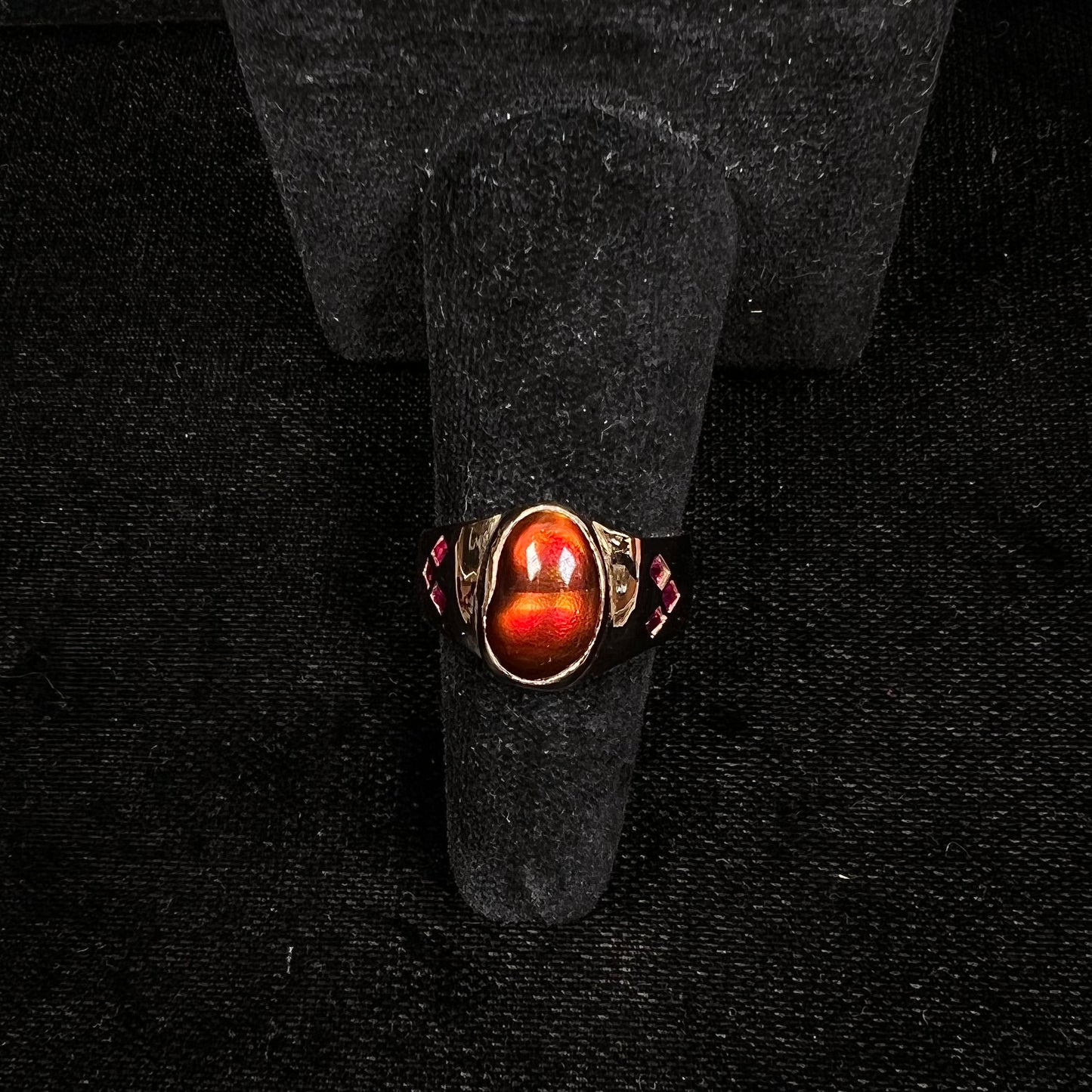 A yellow gold men's ring set with princess cut Burma rubies and a freeform cabochon cut red fire agate from Slaughter Mountain, Arizona.