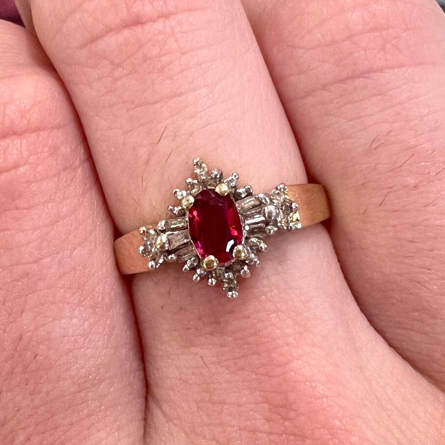 A yellow gold ring set with an oval cut red spinel and diamond rounds and baguettes.