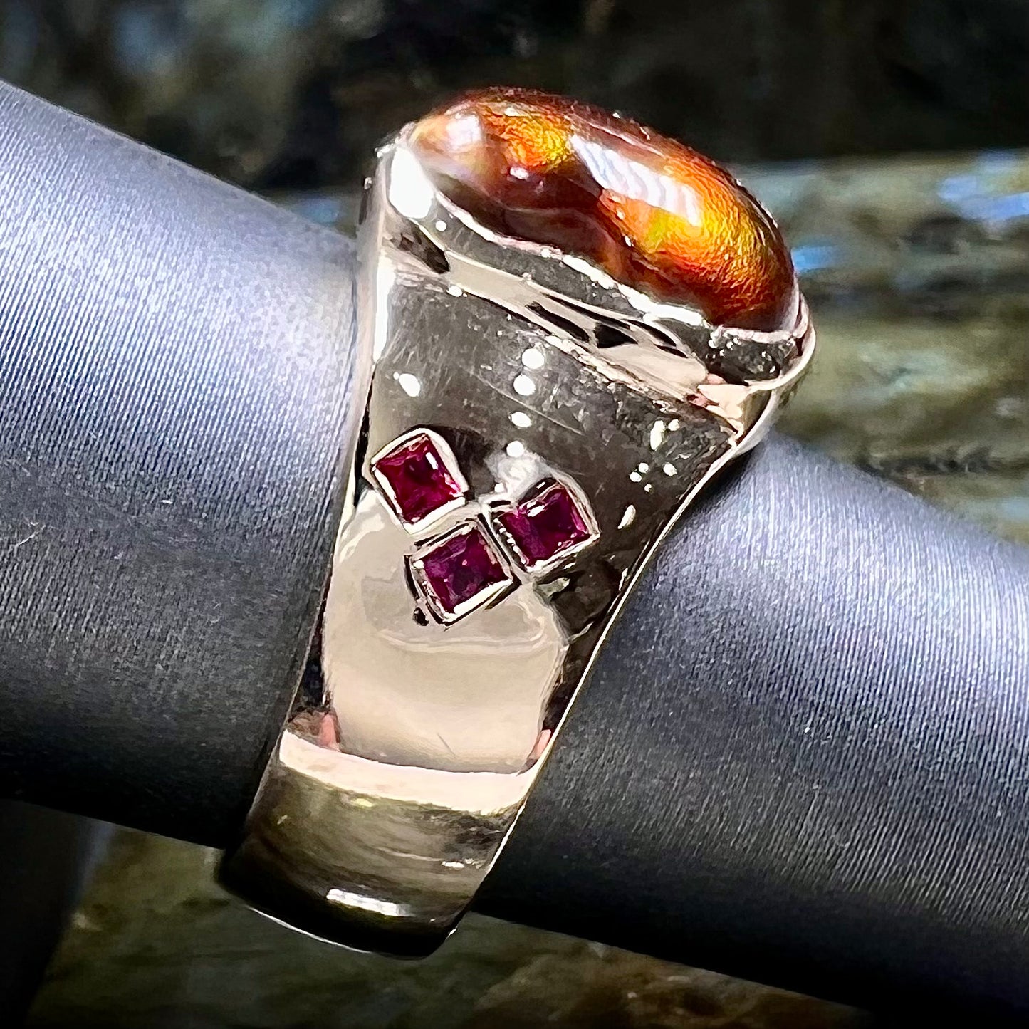 A yellow gold men's ring set with princess cut Burma rubies and a freeform cabochon cut red fire agate from Slaughter Mountain, Arizona.