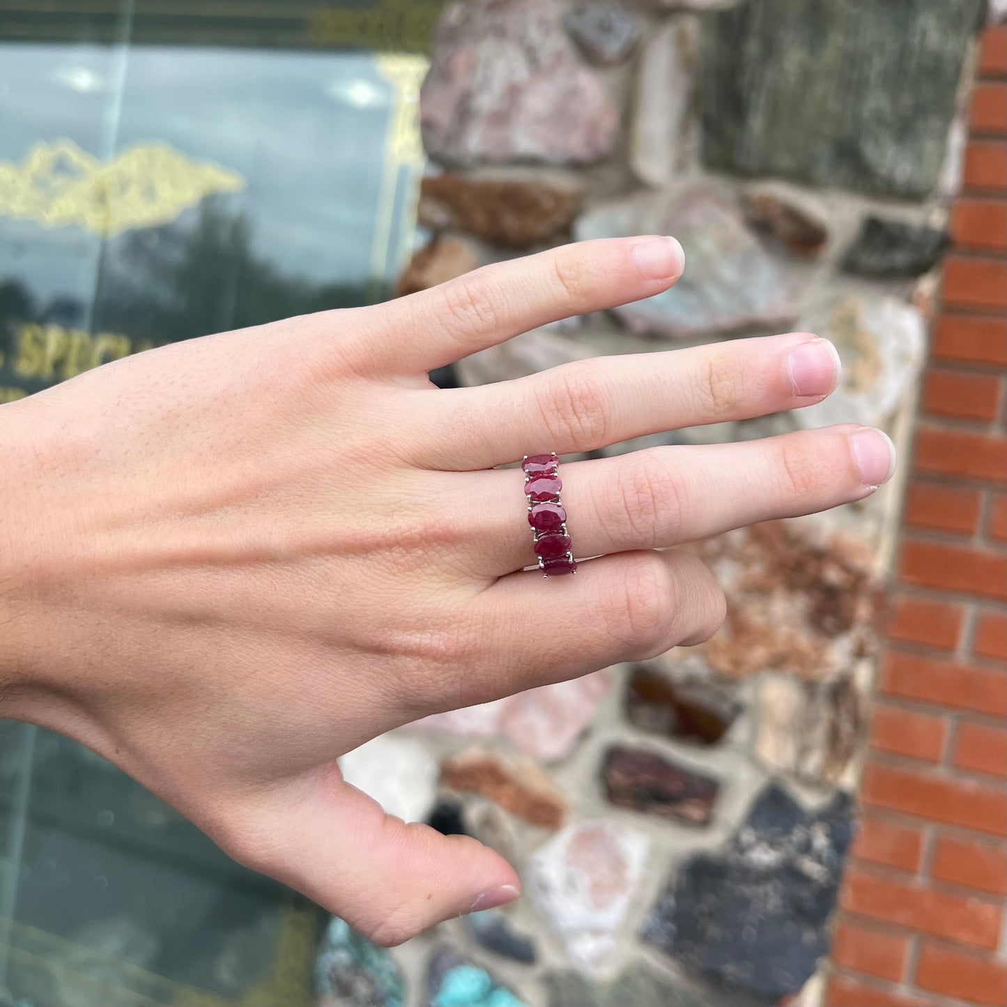 A sterling silver, five stone, faceted oval cut red ruby stackable ring.