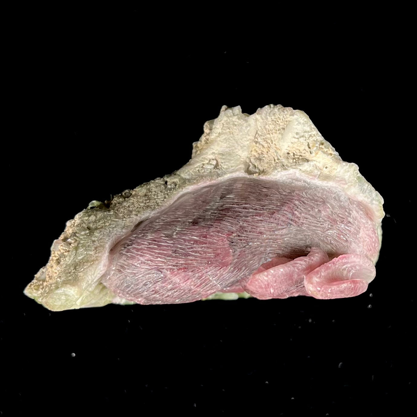 A stone rabbit carved from a conglomeration of watermelon tourmaline crystals by artist, Ronald Stevens.
