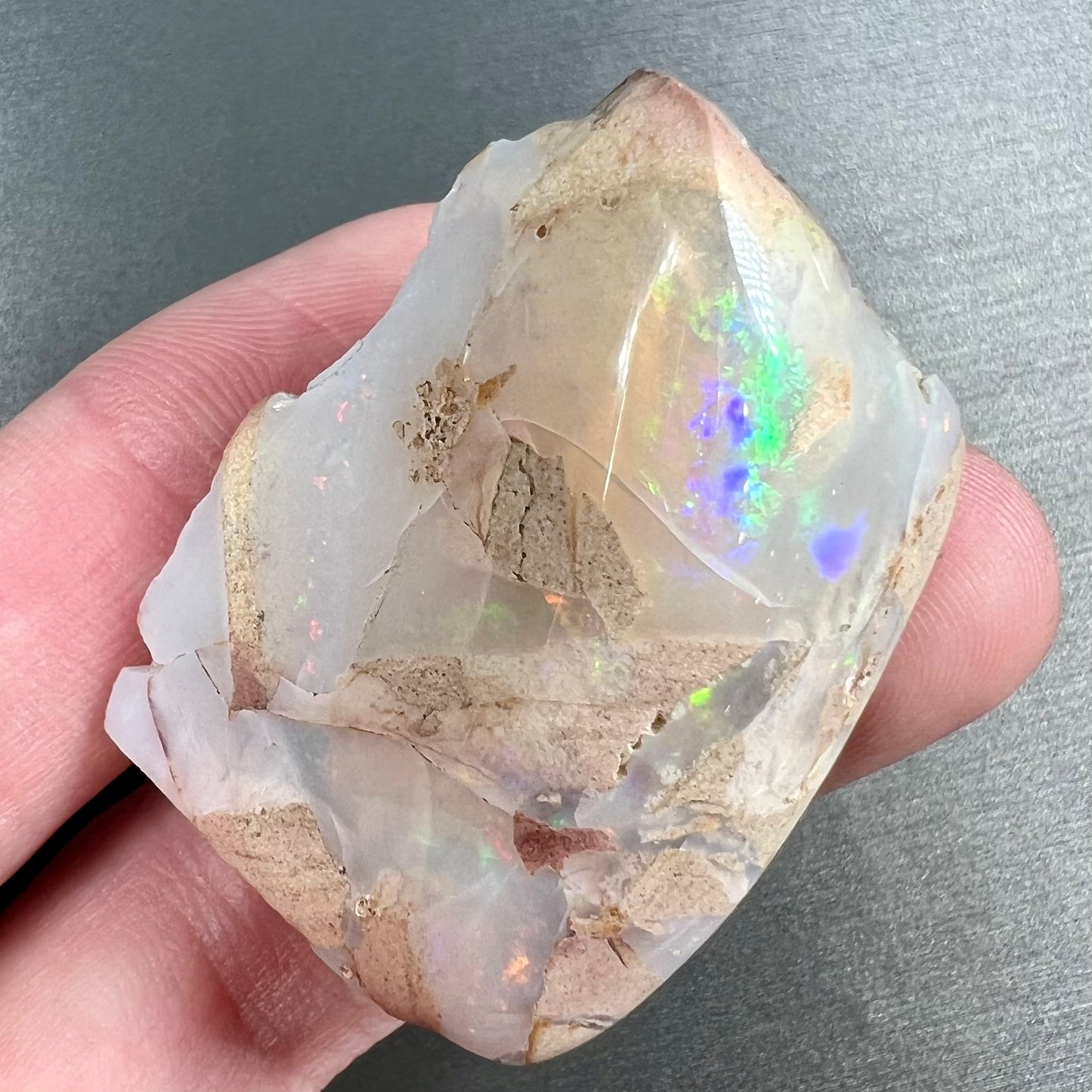 A loose, polished White Cliffs opal specimen.