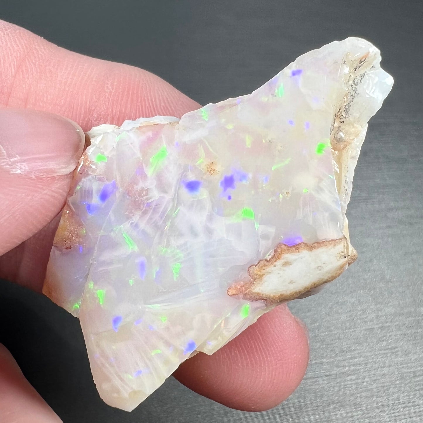 A loose, polished specimen of white crystal opal from Spencer, Idaho, USA.