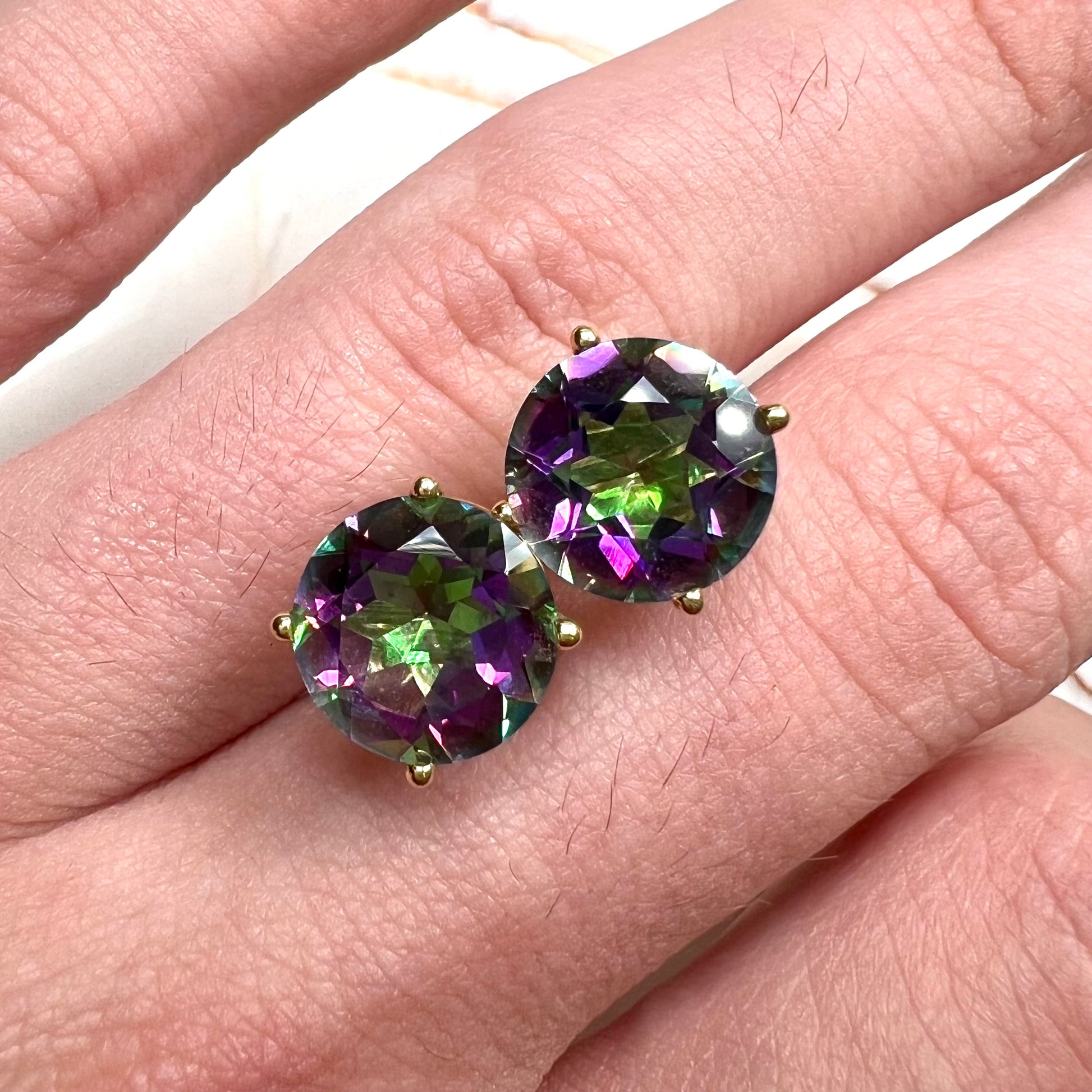 Round cut mystic topaz stones set in yellow gold prong-set push-back earrings.