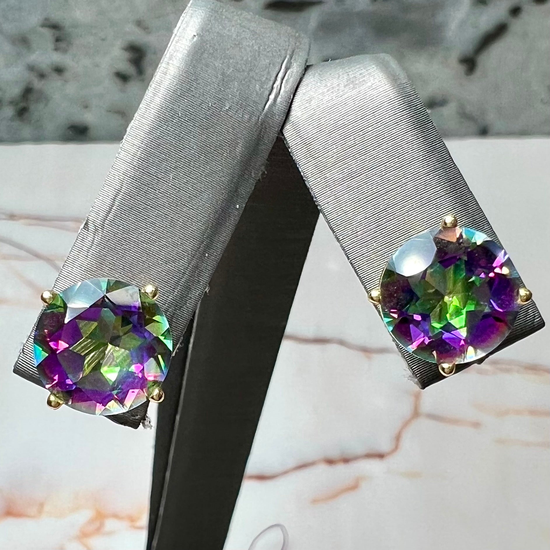 Round cut mystic topaz stones set in yellow gold prong-set push-back earrings.