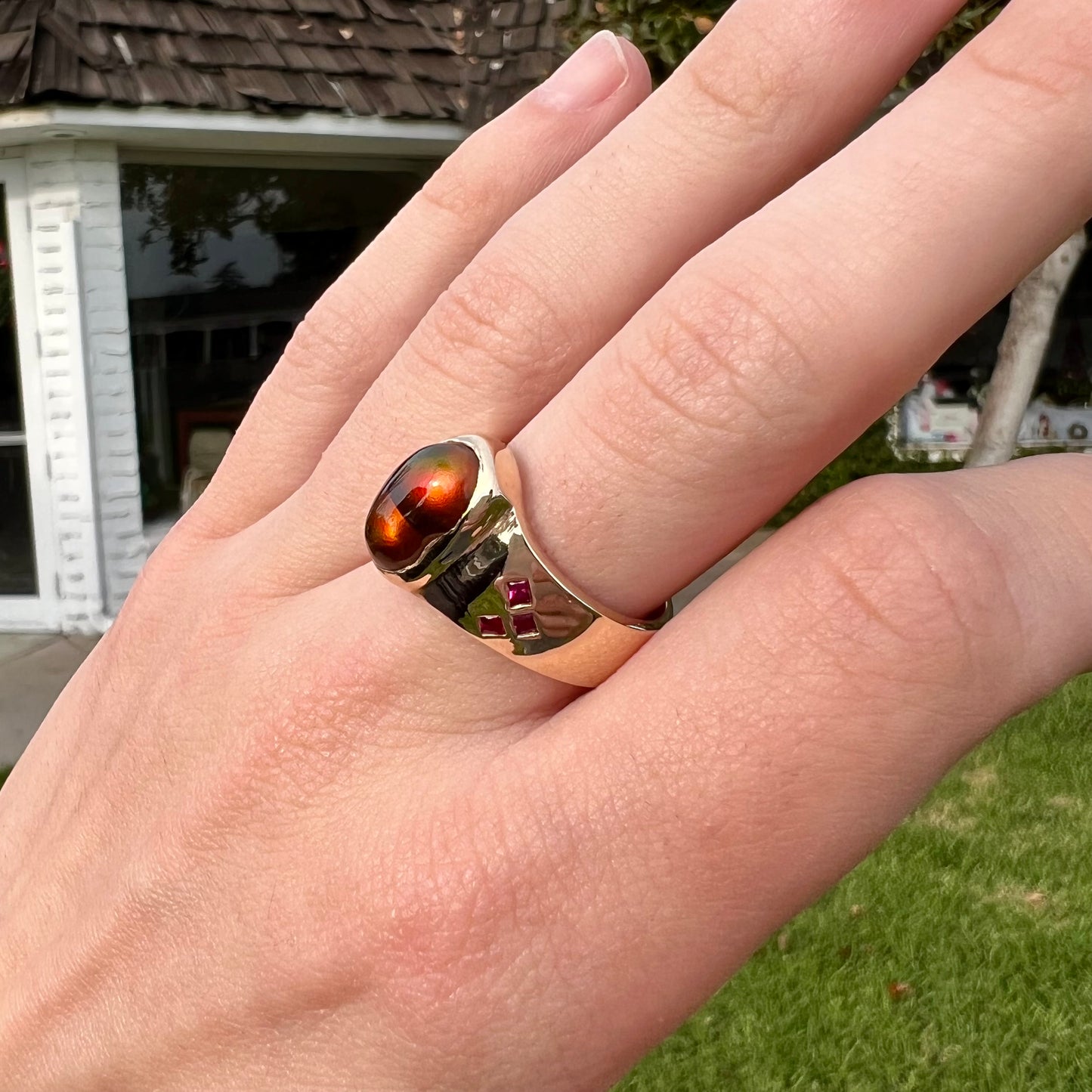 A yellow gold men's ring set with princess cut Burma rubies and a freeform cabochon cut red fire agate from Slaughter Mountain, Arizona.