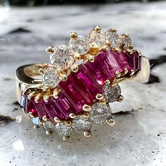 A yellow gold ladies' ring set with 12 baguette cut rubies and 12 Standard Round Brilliant Cut diamonds.
