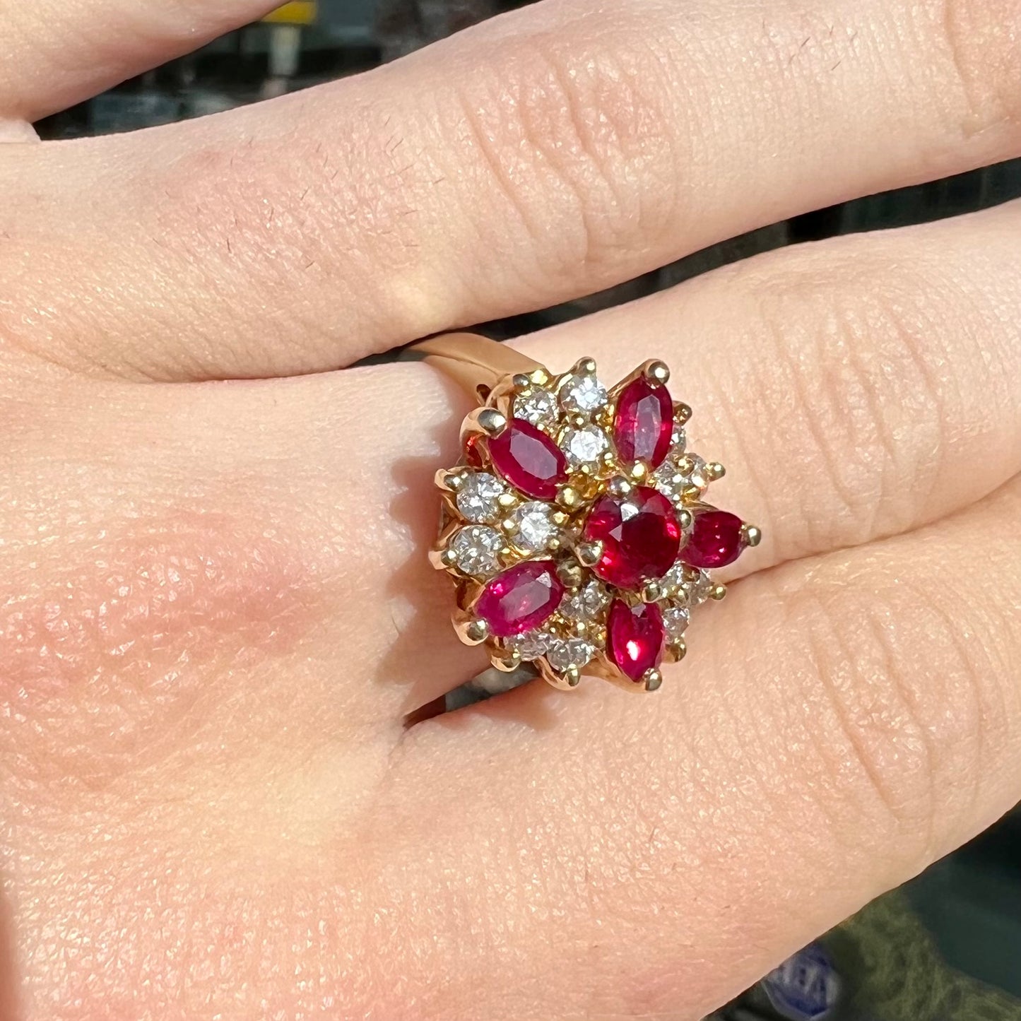 A yellow gold cluster ring set with pigeon blood red Burma rubies and diamonds.