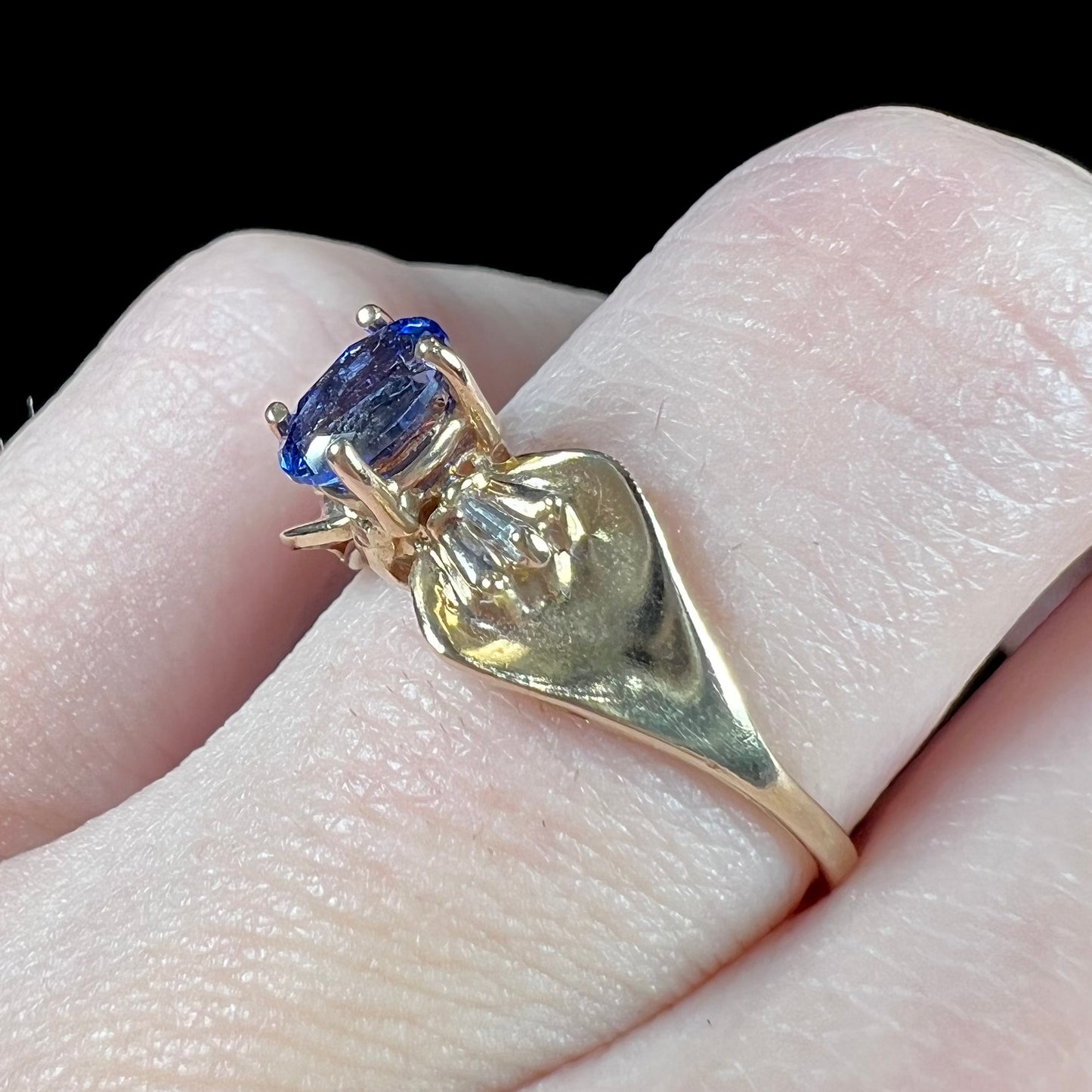 A natural blue sapphire and diamond baguette ring cast in yellow gold.