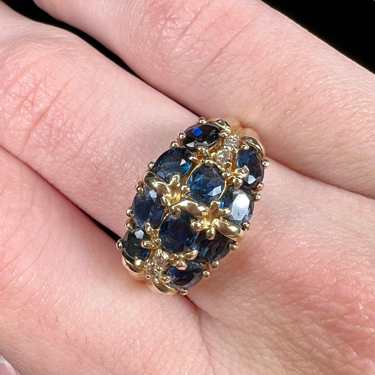 A vintage ladies' blue sapphire and diamond cluster ring cast in yellow gold.