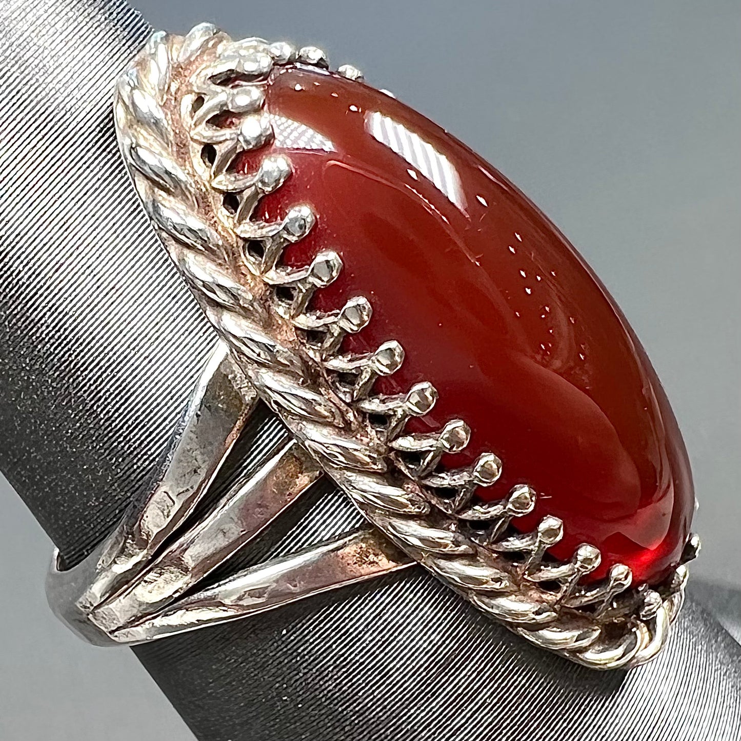 A split shank silver ring set with a brown sard stone in a rope bezel with small prongs.