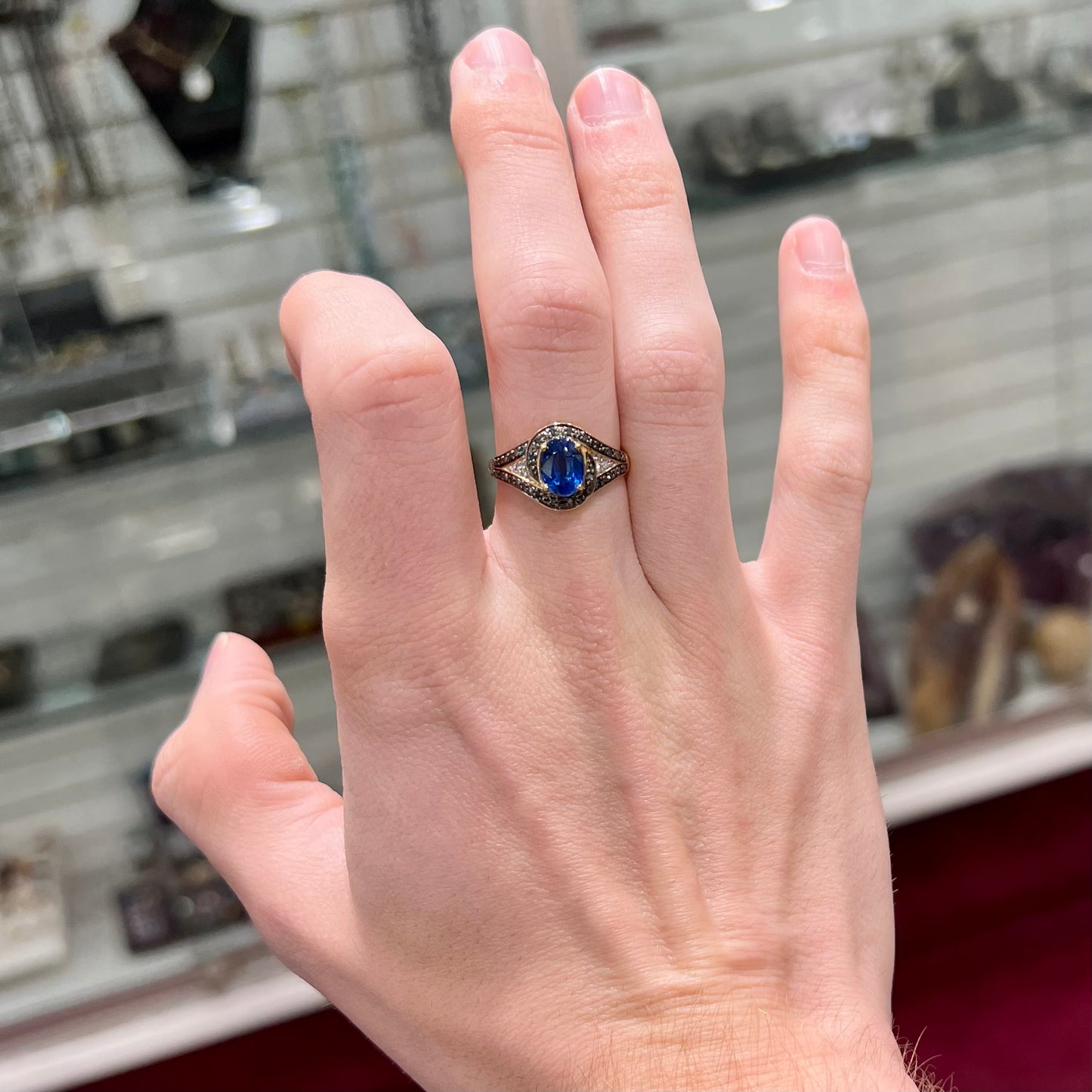 A ladies' oval cut blue kyanite twist ring pave set with blue and white diamond accents.