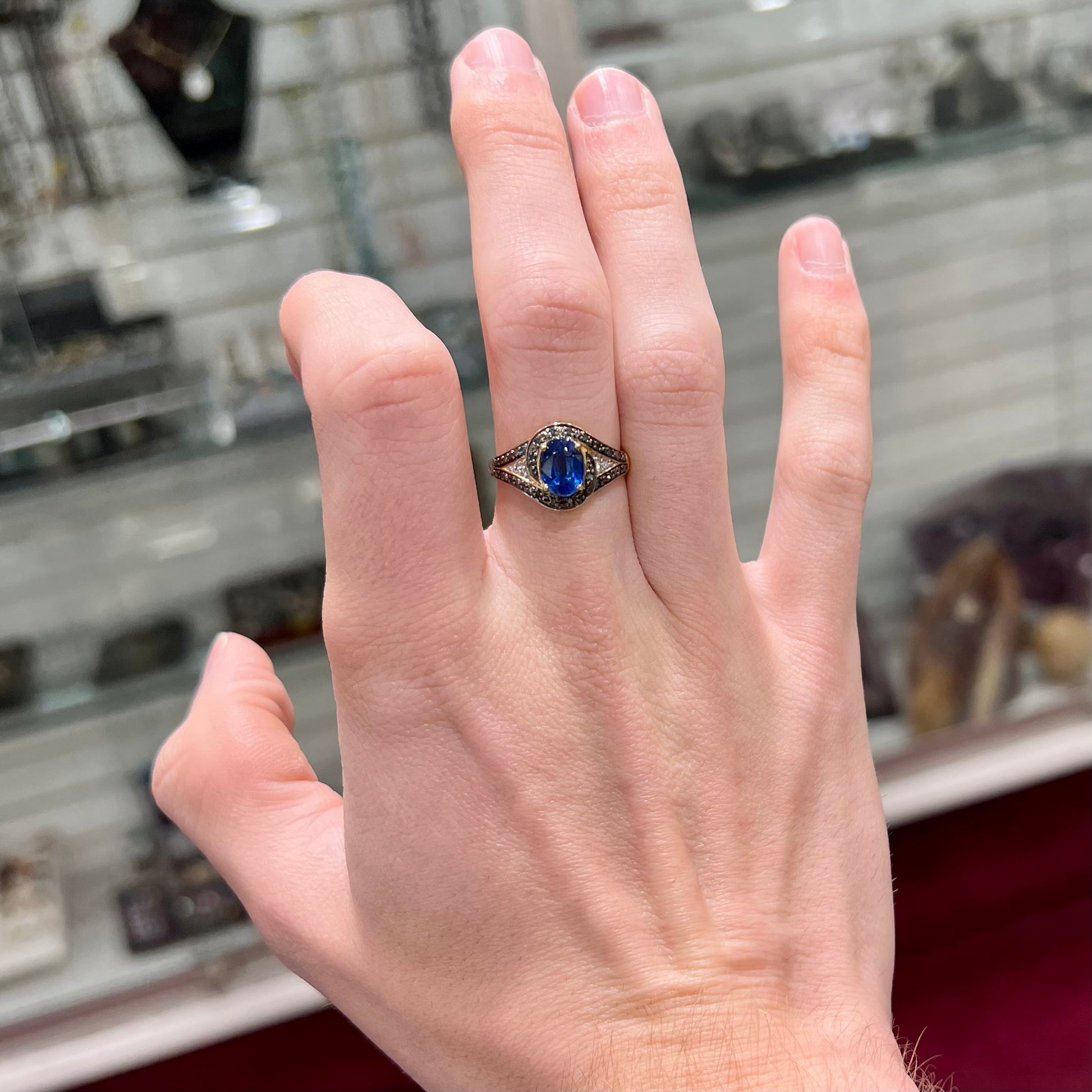 A ladies' oval cut blue kyanite twist ring pave set with blue and white diamond accents.