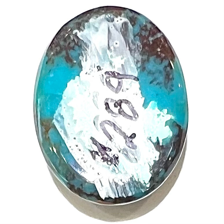 An oval cabochon cut blue turquoise stone with red cuprite inclusions from Royston District, Nevada.