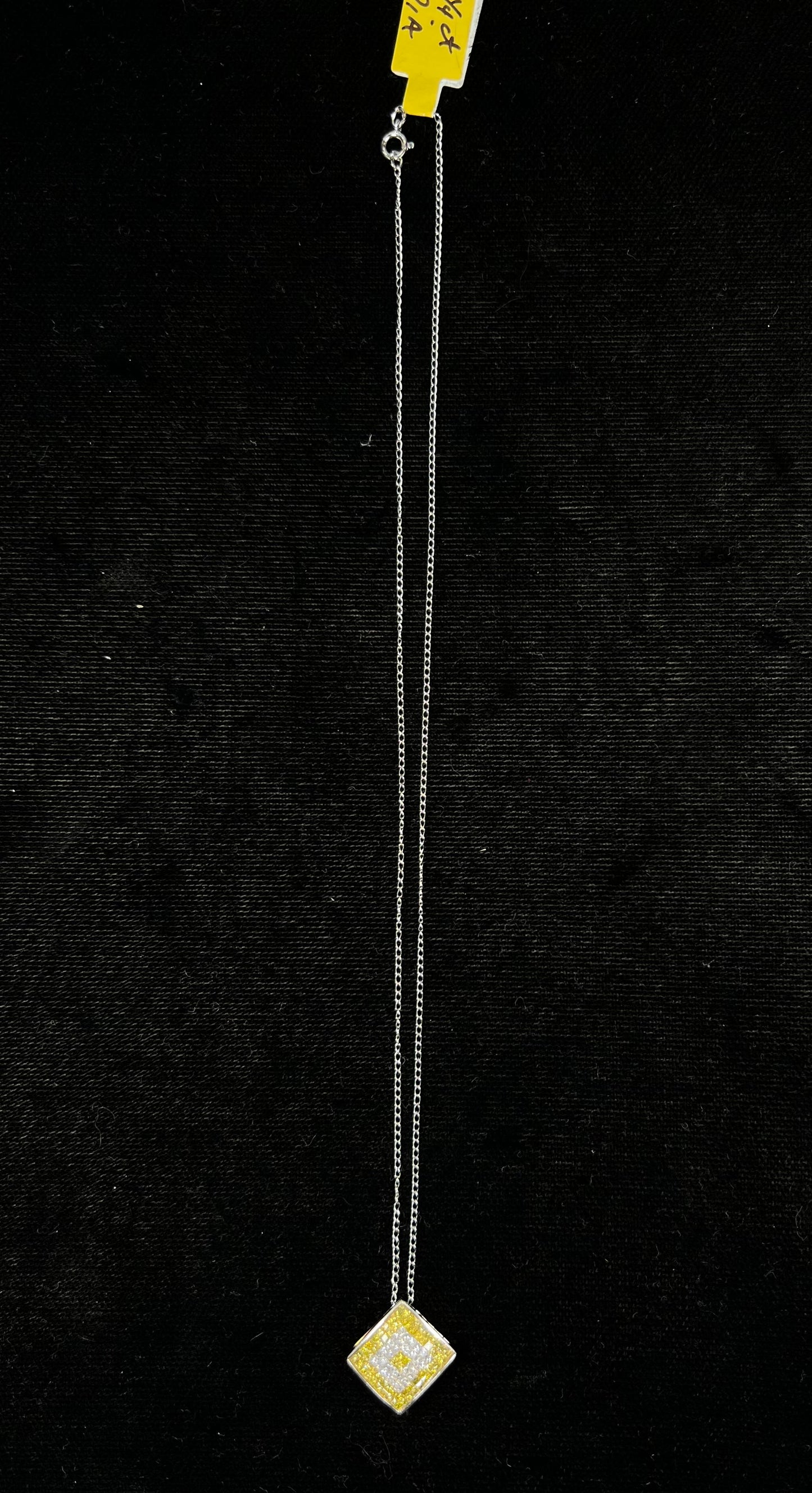 A square shaped necklace set with princess cut yellow and white diamonds in a white gold setting on a white gold chain.