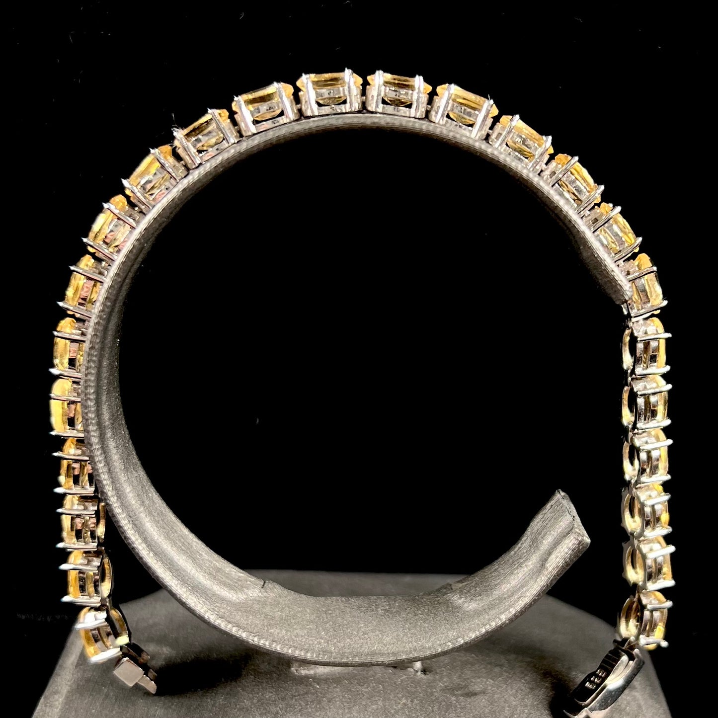 A sterling silver ladies' tennis bracelet set with faceted oval cut citrine stones.