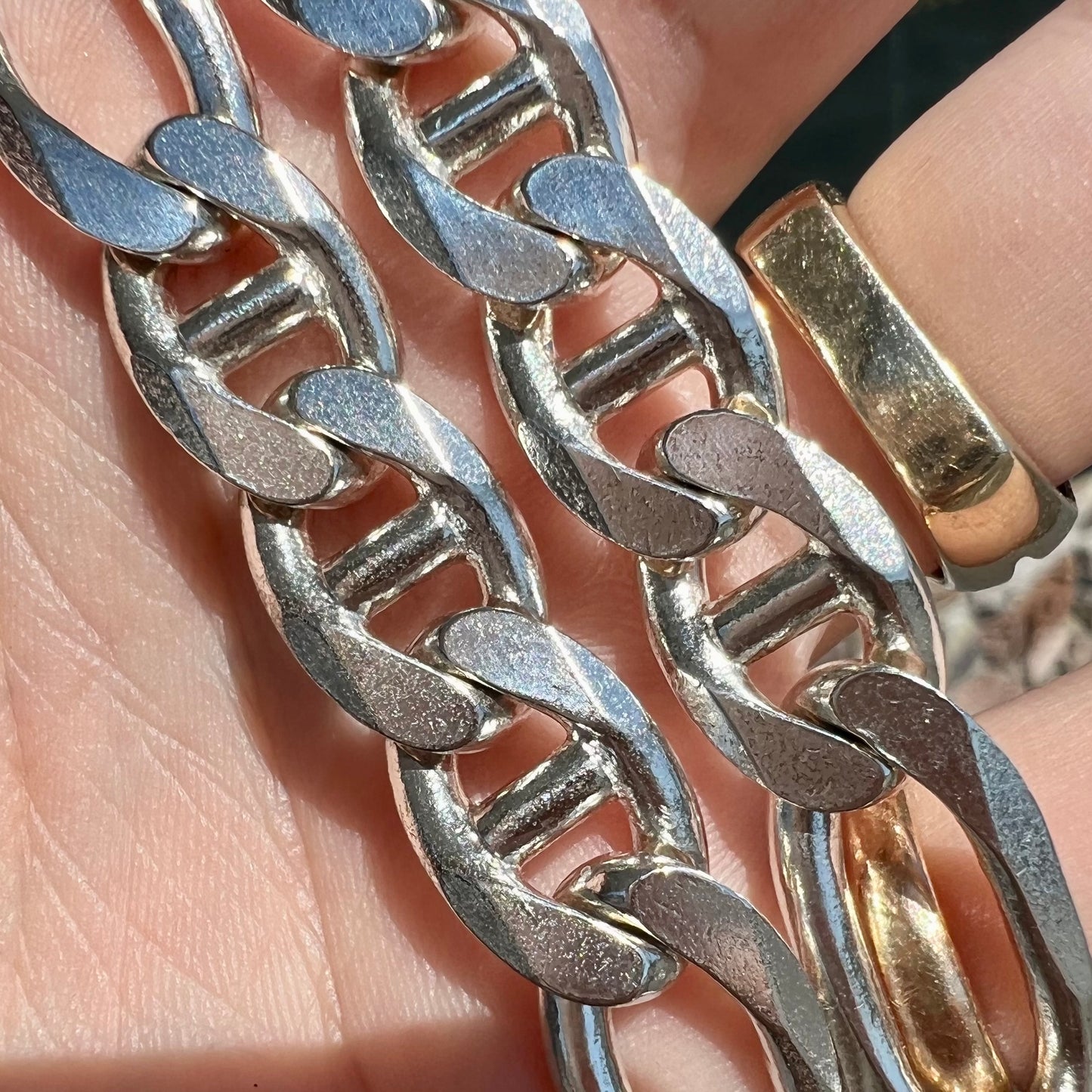 A men's sterling silver figaro anchor chain. The chain measures 22 inches in length and the links are 11mm wide.