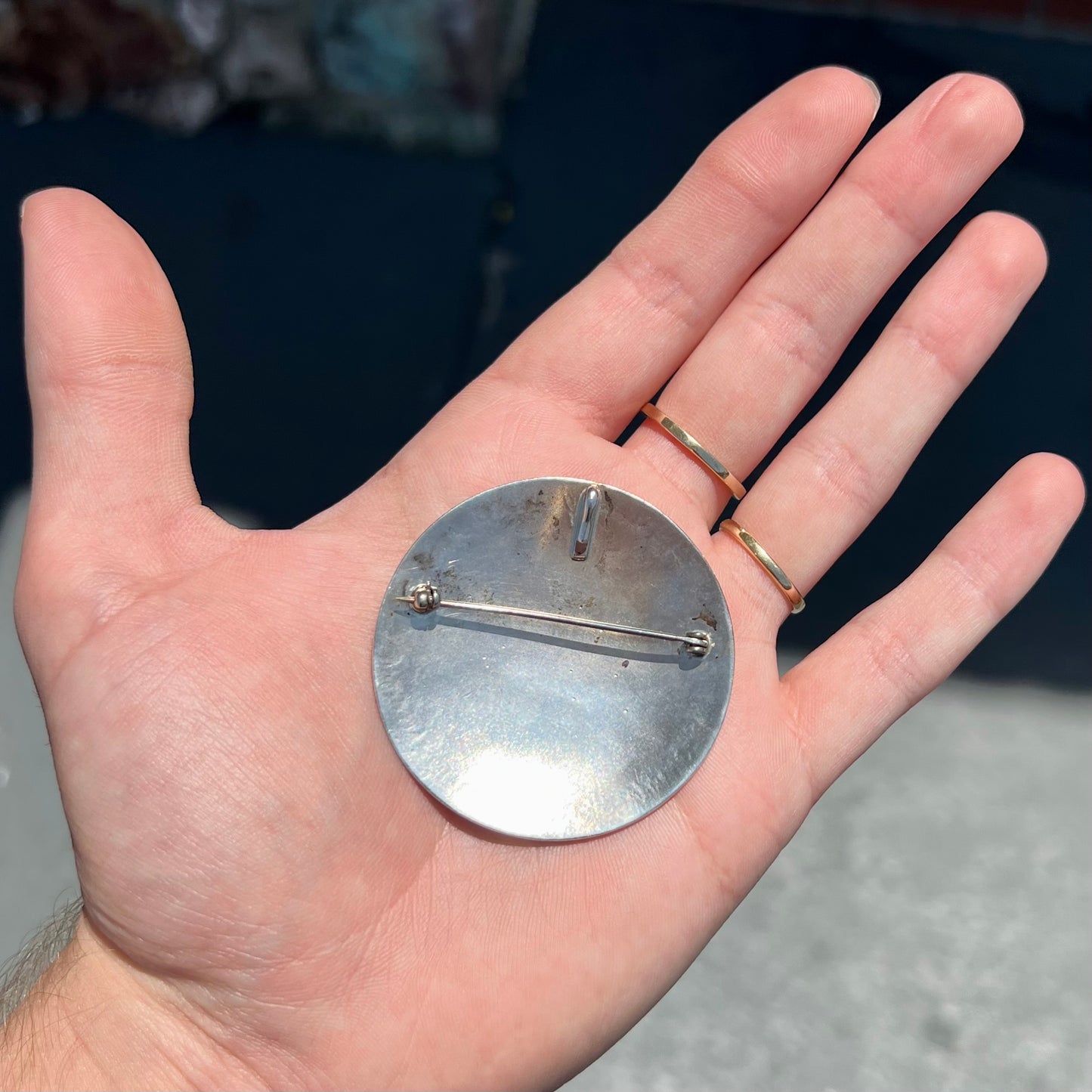 A silver pendant of two flying cranes and two roadrunners inlaid with turquoise, coral, and mother of pearl.