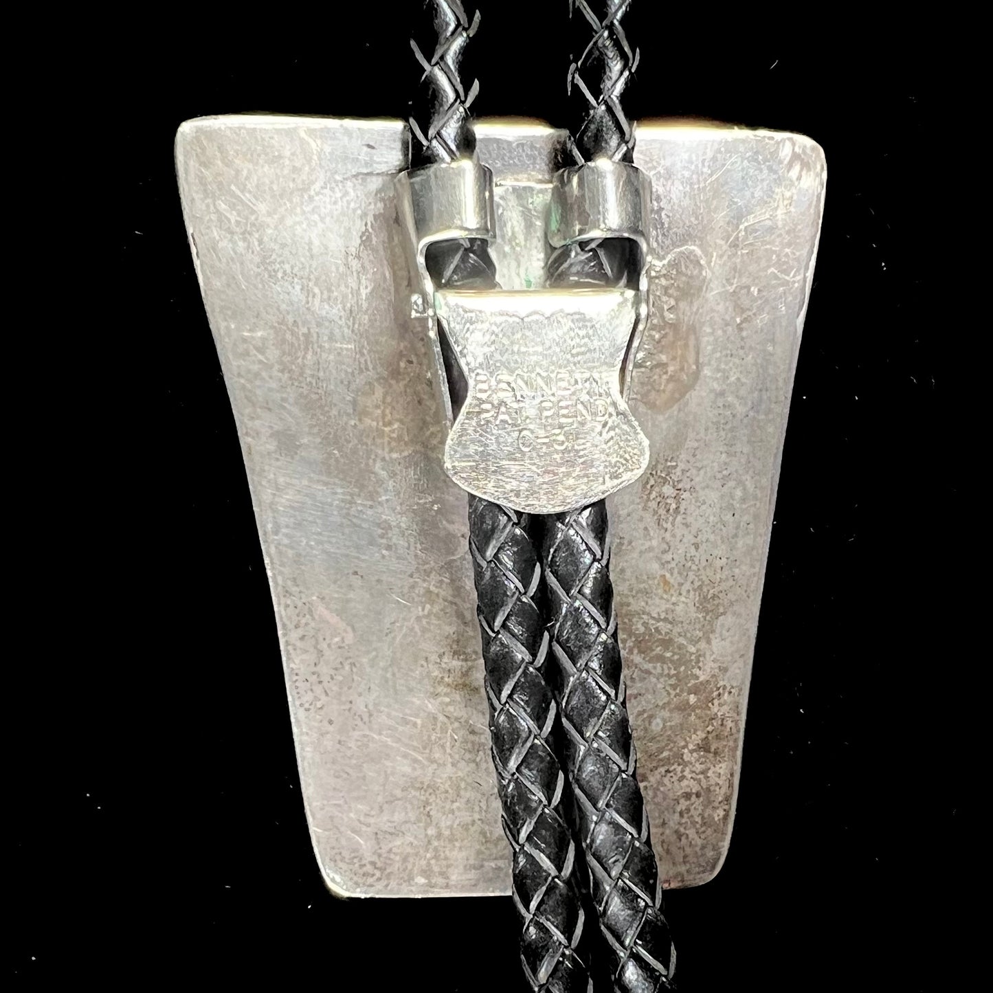 A vintage sterling silver Navajo bolo tie set with Morenci turquoise, handmade by artist Delvin Nelson.