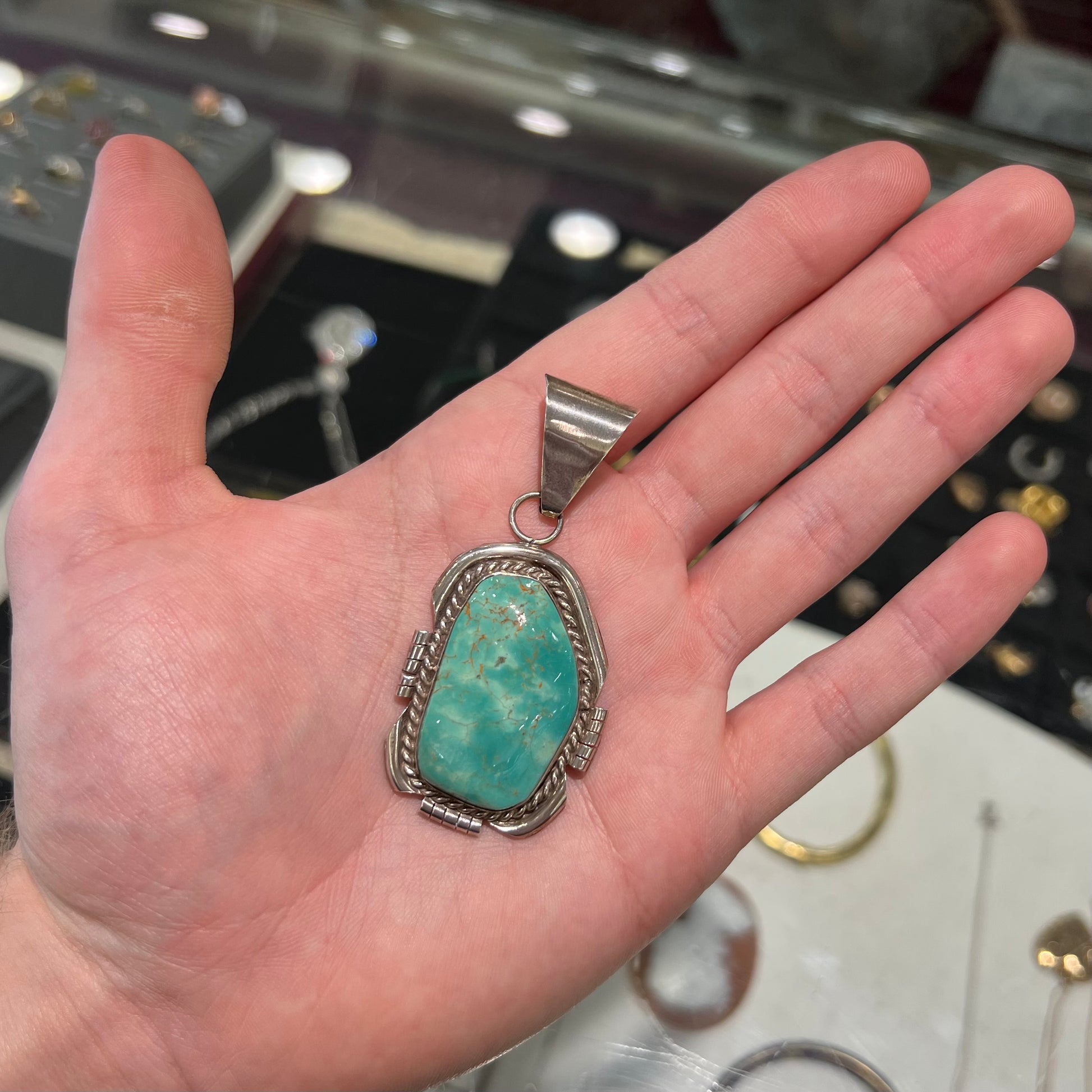 A men's silver Navajo pendant set with a turquoise stone from Pilot Mountain Mine, Nevada.