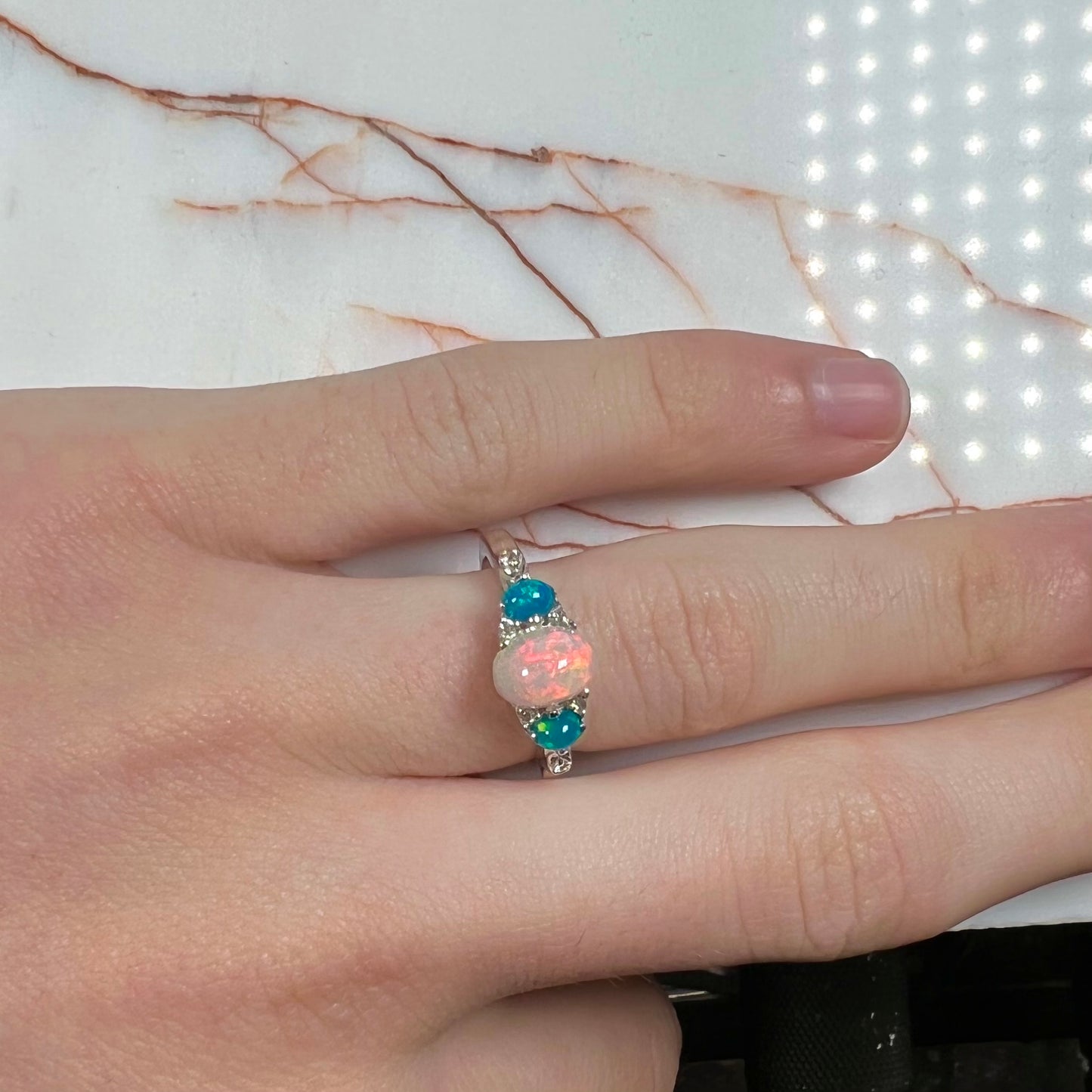 A sterling silver ring, earring, and necklace set made of Ethiopian opals and cubic zirconia.