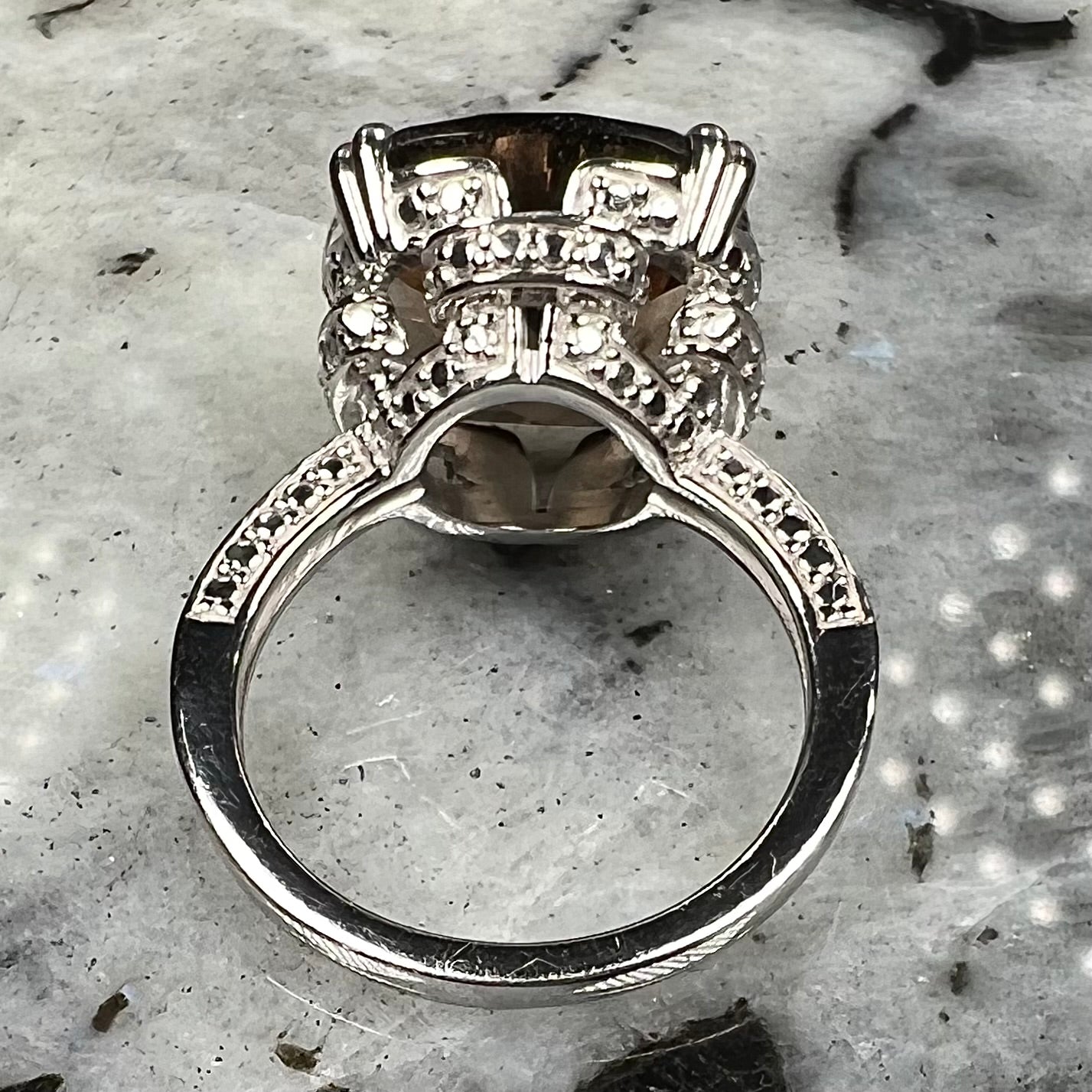 A sterling silver, cushion cut smoky quartz solitaire ring.
