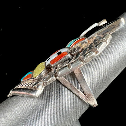 A sterling silver ring handmade in the motif of a Zuni Indian horned kachina set with onyx, turquoise, coral, mother of pearl, and sulfur quartz stones.