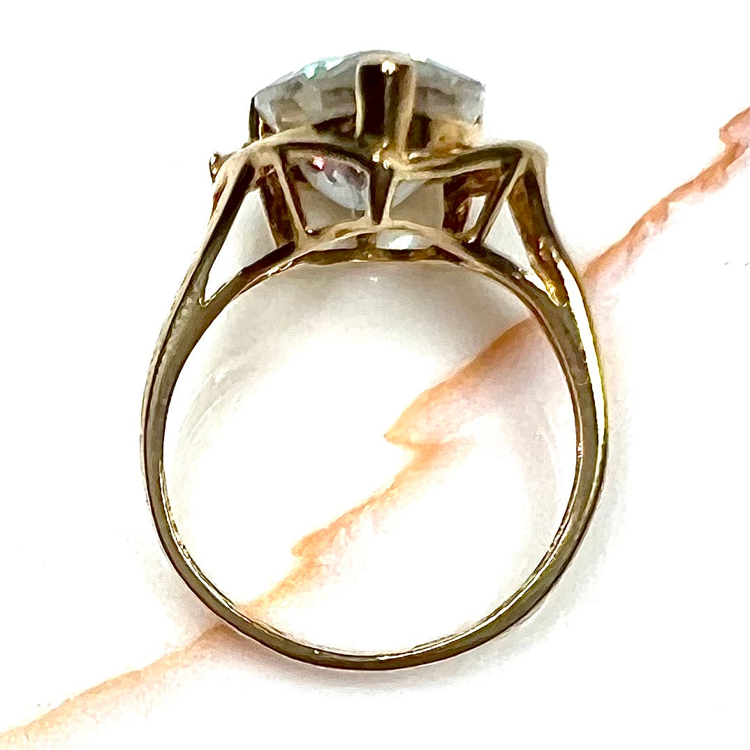 Pear shape green and pink mystic topaz set in a yellow gold ring with a single round diamond.