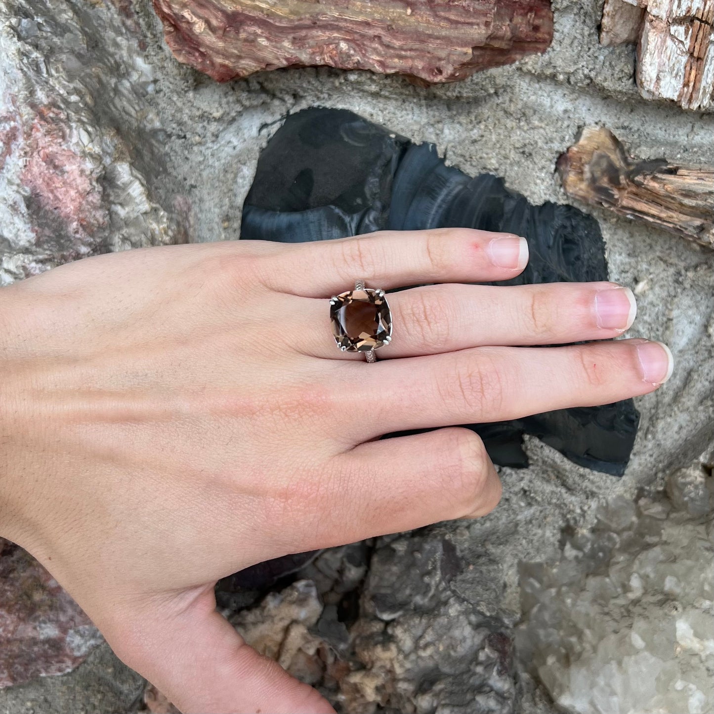 A sterling silver, cushion cut smoky quartz solitaire ring.