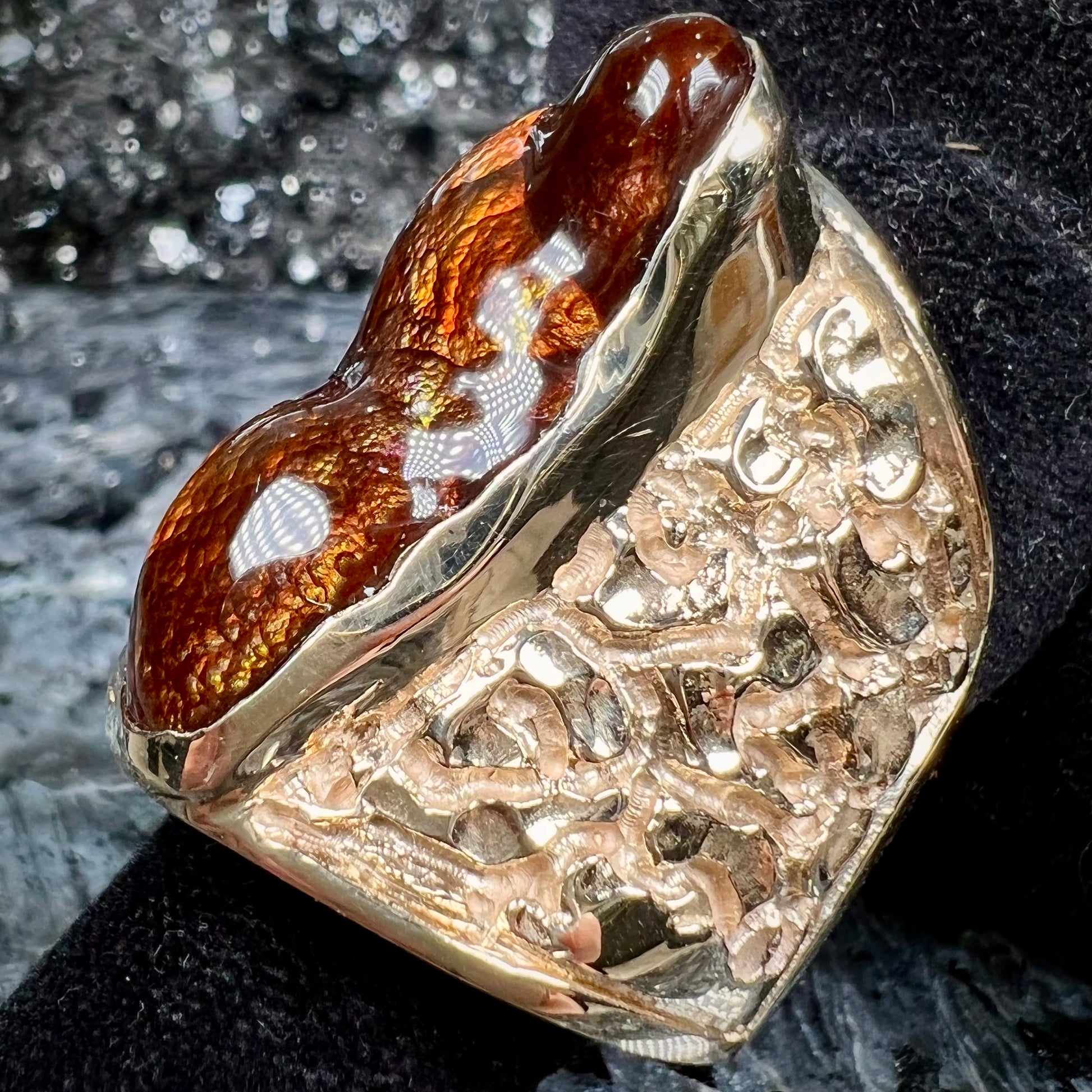 A large nugget style men's fire agate ring cast in yellow gold.  The fire agate is predominantly orange and green.