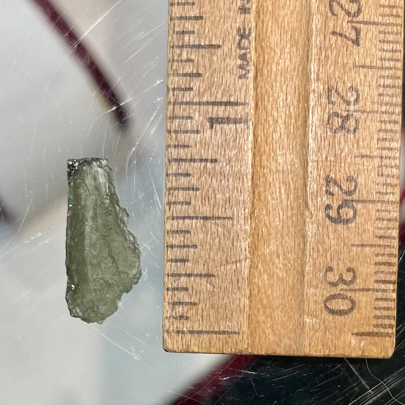 A loose, natural moldavite crystal.