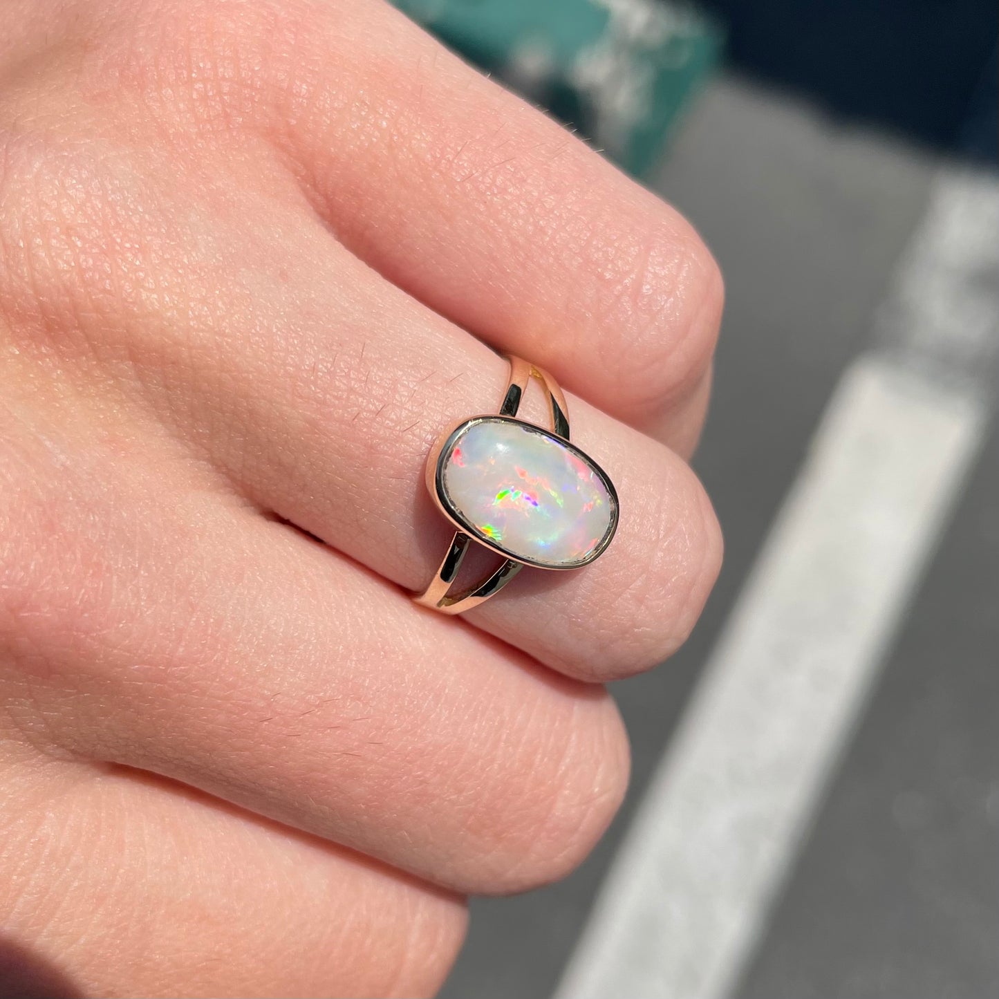 A handmade split shank white opal solitaire ring in yellow gold.