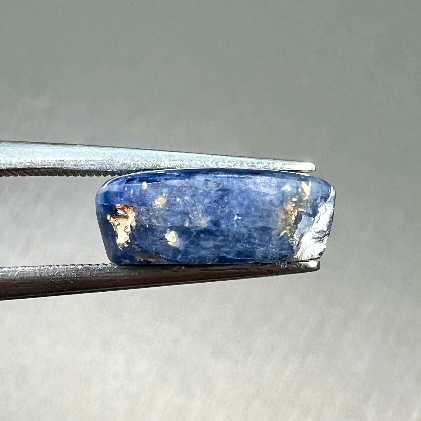 A loose, oval cabochon cut blue trapiche star sapphire stone.