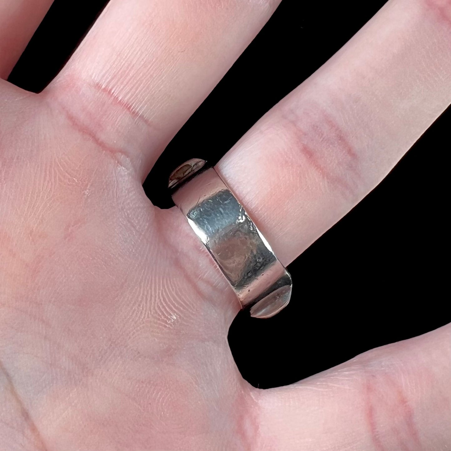 A sterling silver ring inlaid with onyx, turquoise, coral, lapis lazuli, and mother of pearl stones.