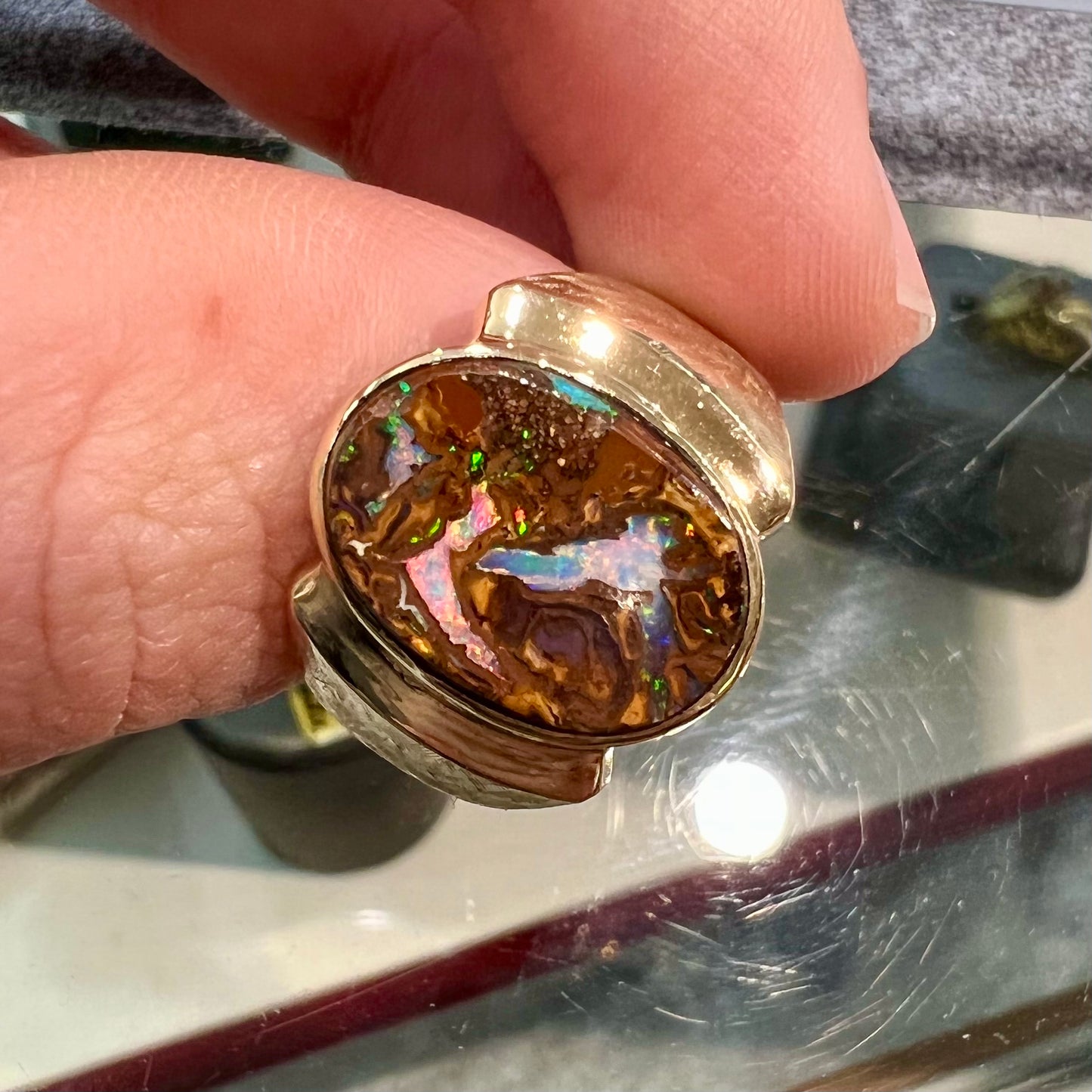 A Koroit boulder opal men's ring in brushed yellow gold.