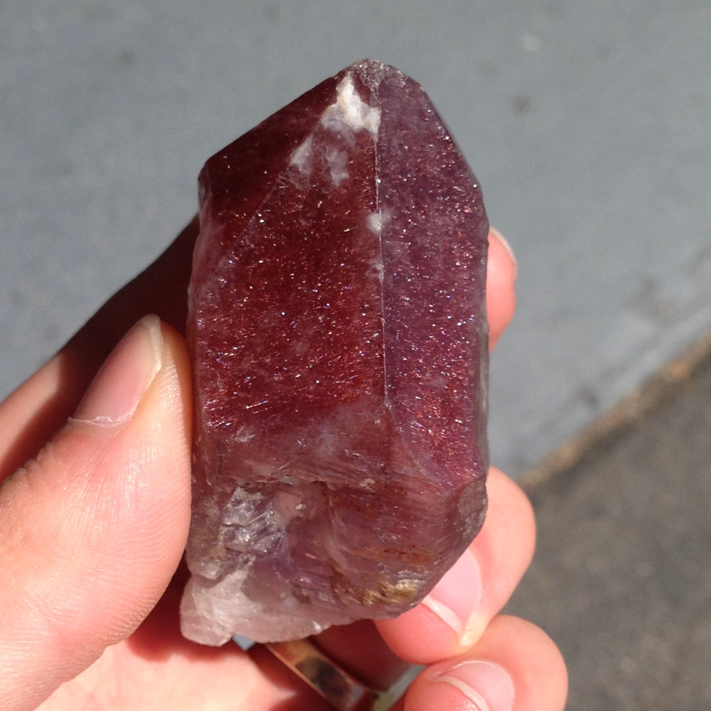 A large, oval cabochon cut strawberry quartz. The stone has a trapiche star-like pattern.