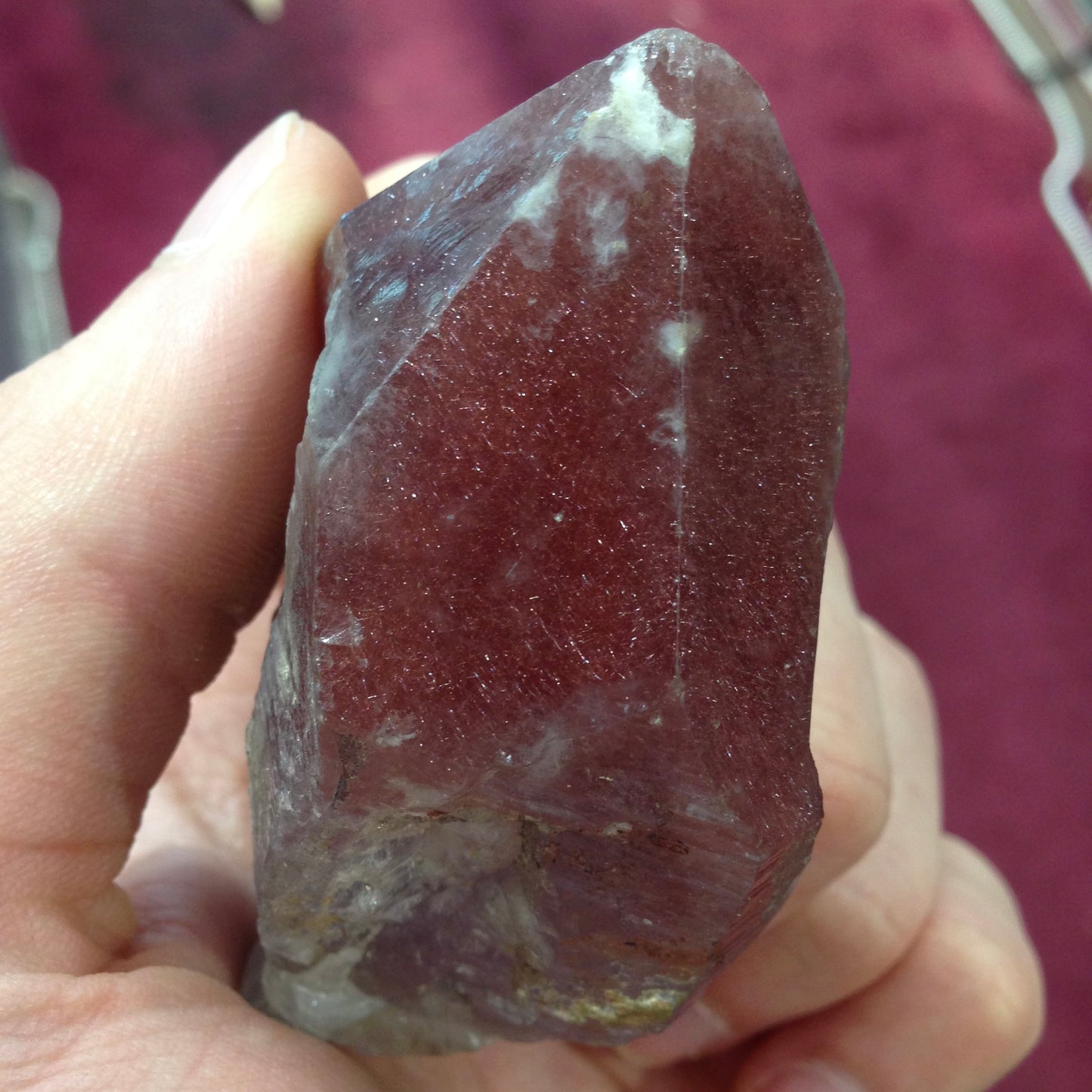 A large, oval cabochon cut strawberry quartz. The stone has a trapiche star-like pattern.