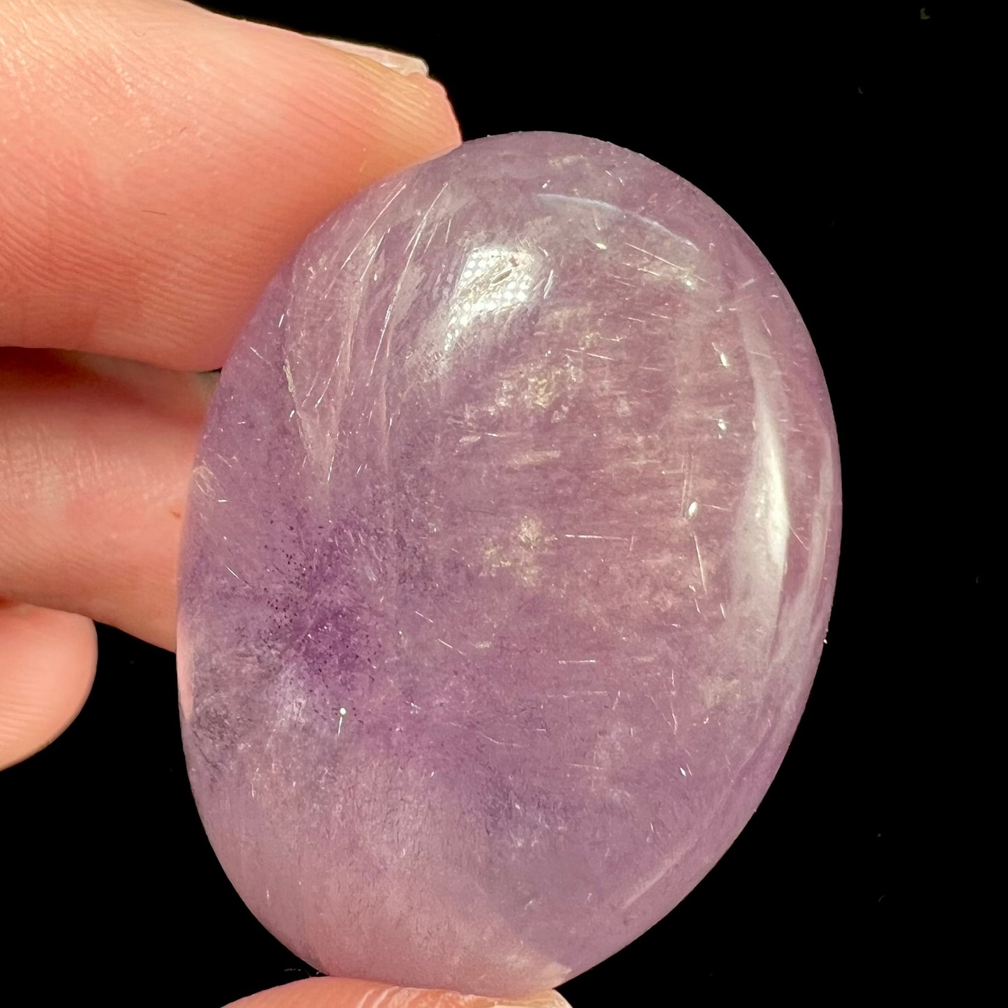 A cabochon cut red amethyst stone from Mexico. The piece shows a faint star.