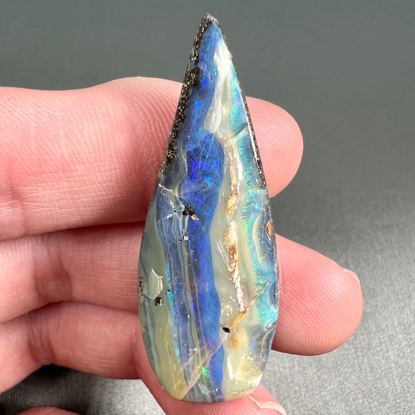A loose, pear shaped boulder opal stone from Queensland, Australia.
