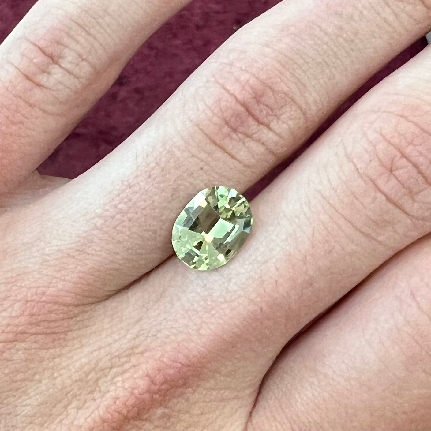 A loose mint green, oval cut garnet stone.