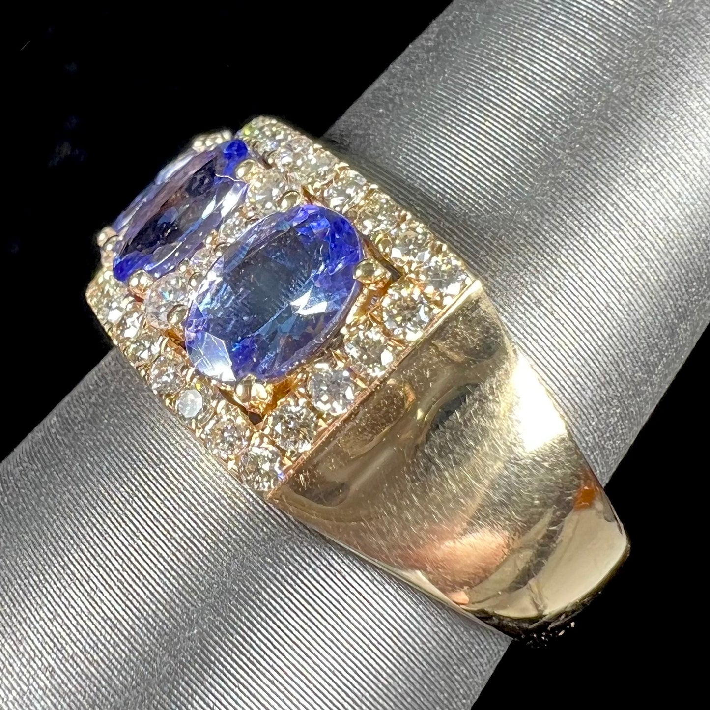 A gold and diamond ladies' band set with five oval cut tanzanite stones.