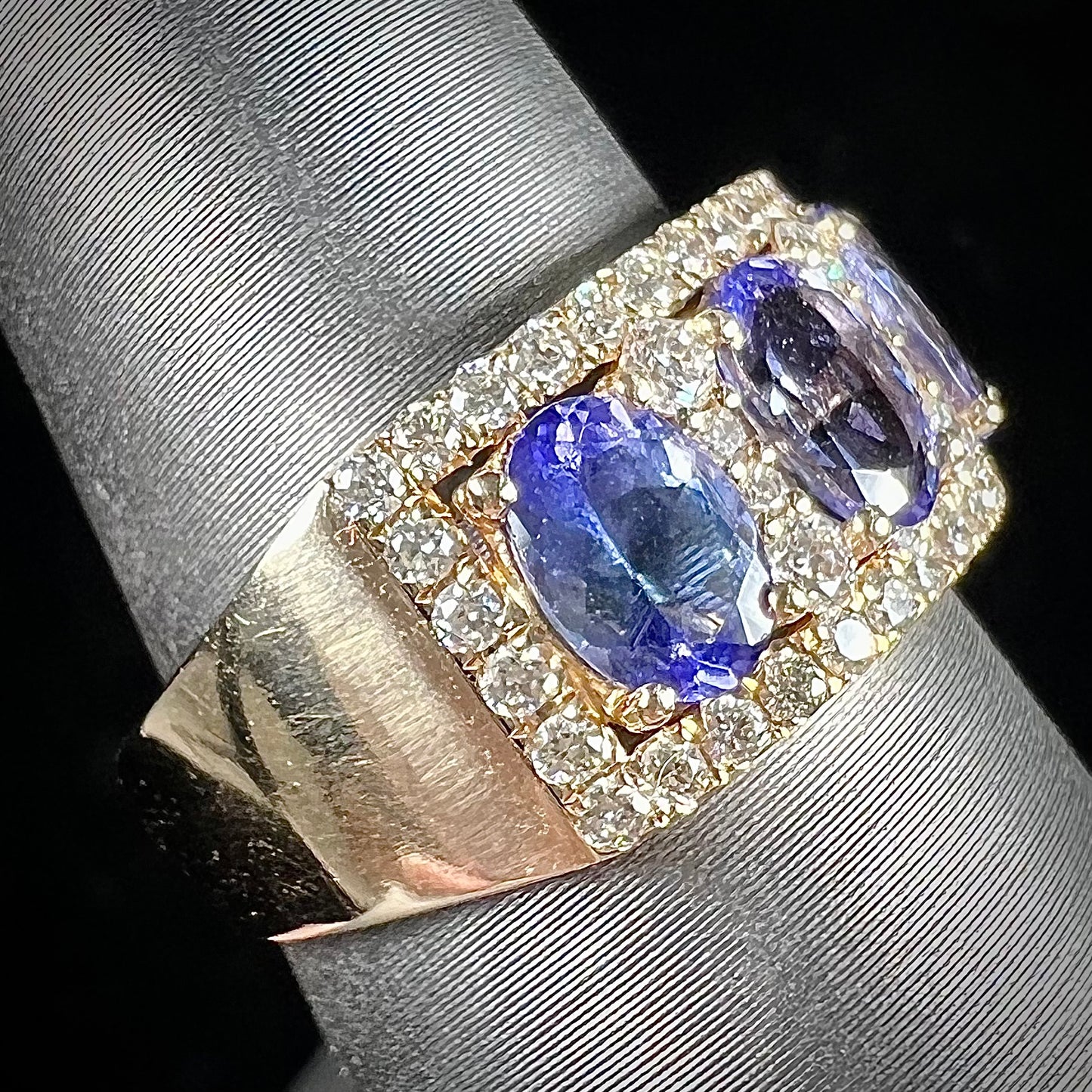 A gold and diamond ladies' band set with five oval cut tanzanite stones.