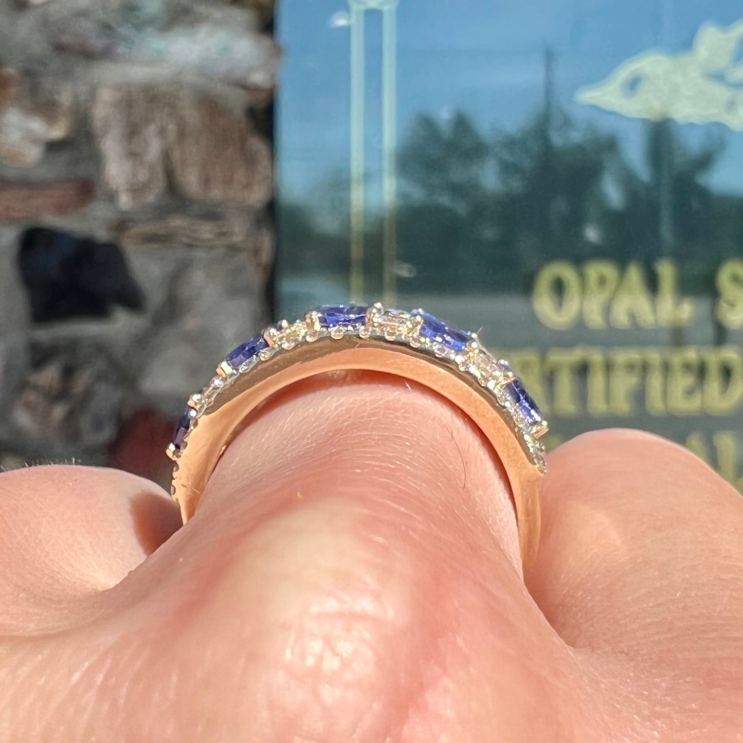 A gold and diamond ladies' band set with five oval cut tanzanite stones.