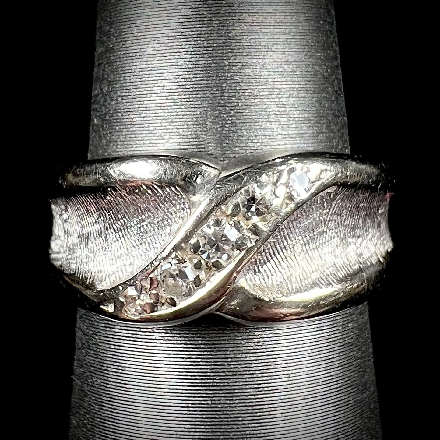 A ladies' white gold five stone single cut diamond ring.  The metal of the ring has a textured finish.