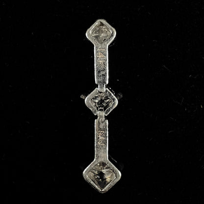 A ladies' white gold three stone drop pendant set with princess cut diamonds.  There are two points of articulation.