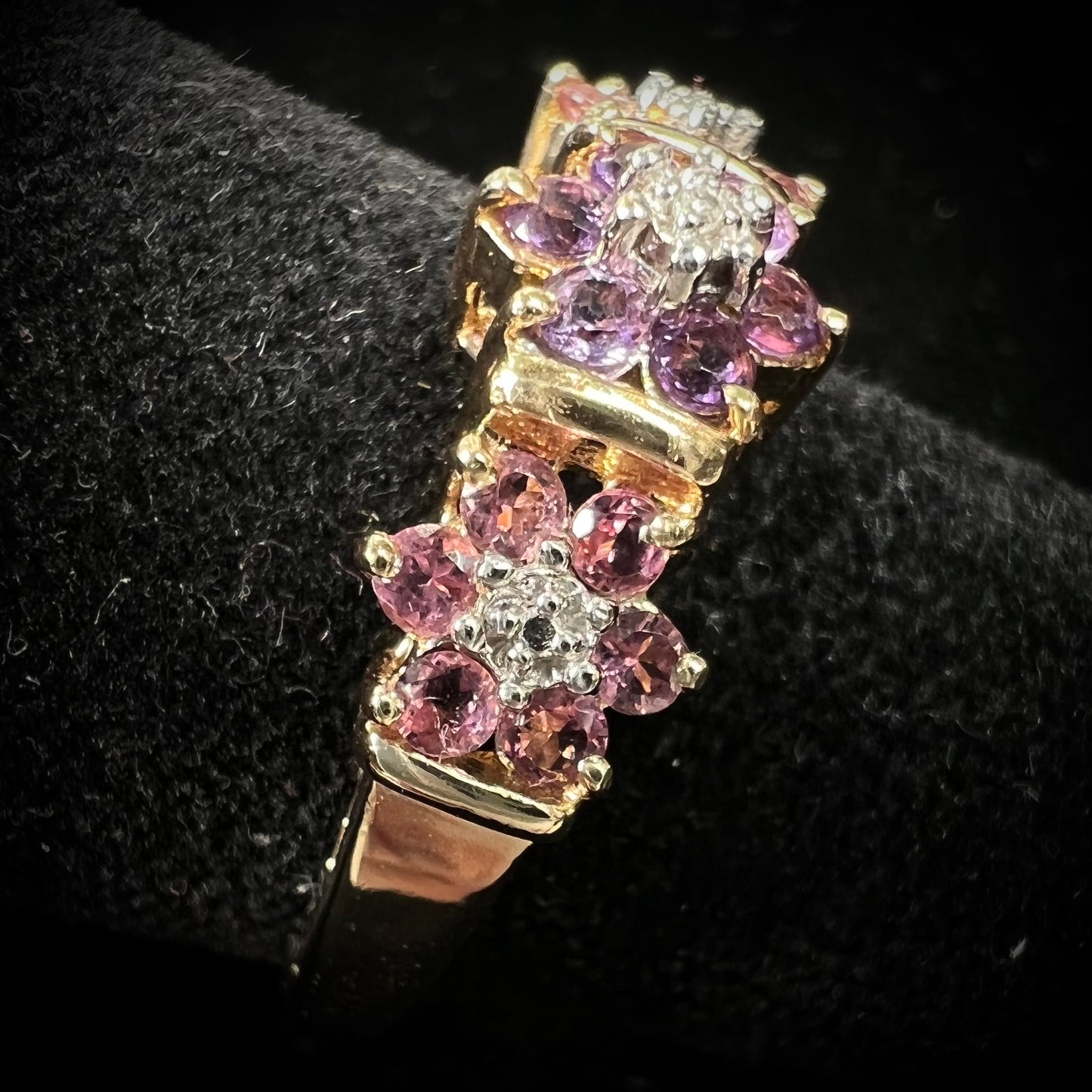 A vintage ladies' flower ring set with set with amethyst and pink tourmaline petals with a diamond center stone.