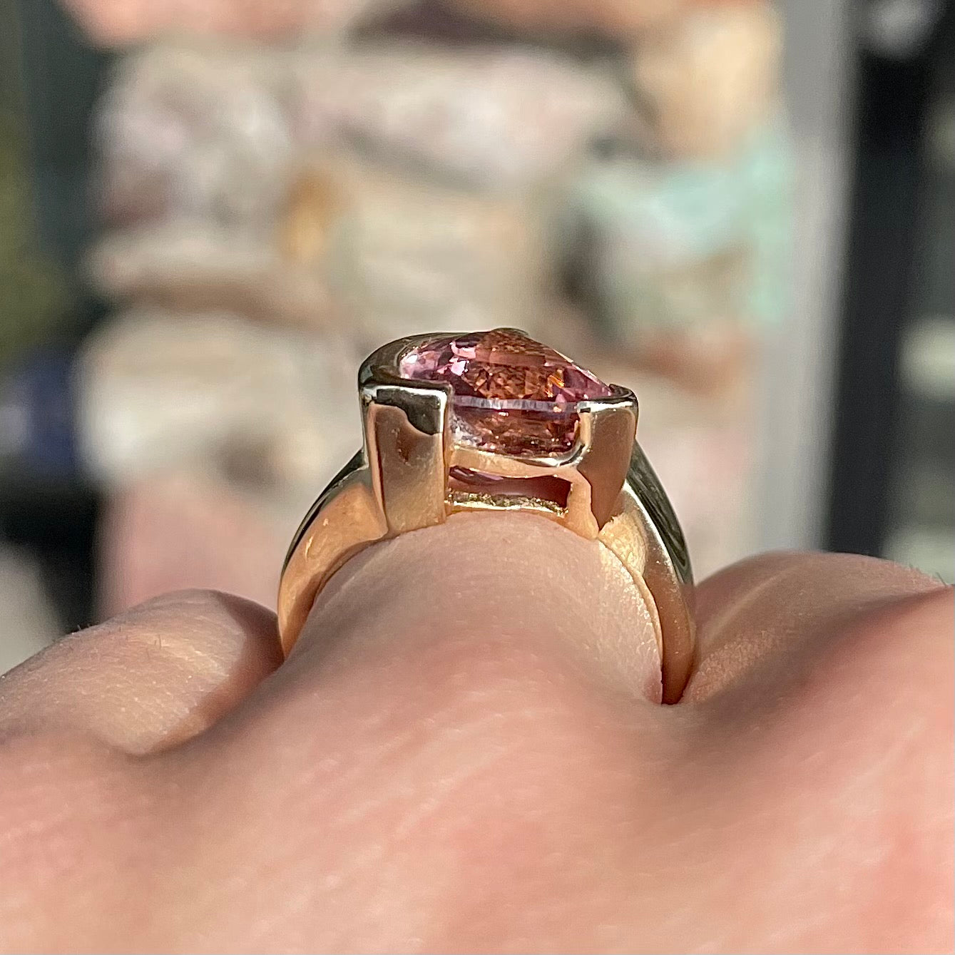 A unisex trillion cut pink tourmaline ring half bezel set in 14k yellow gold.